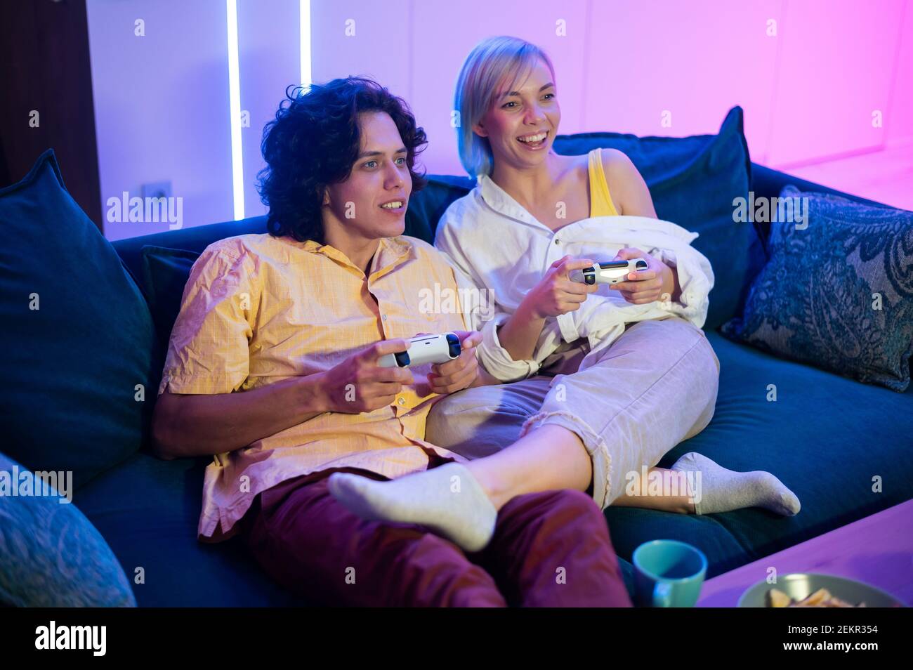 Hübscher junger Mann beizubringen, wie man die Videospiele zu seiner Freundin auf der Couch, Konzept über home-Entertainment, Videospiele zu spielen. Stockfoto