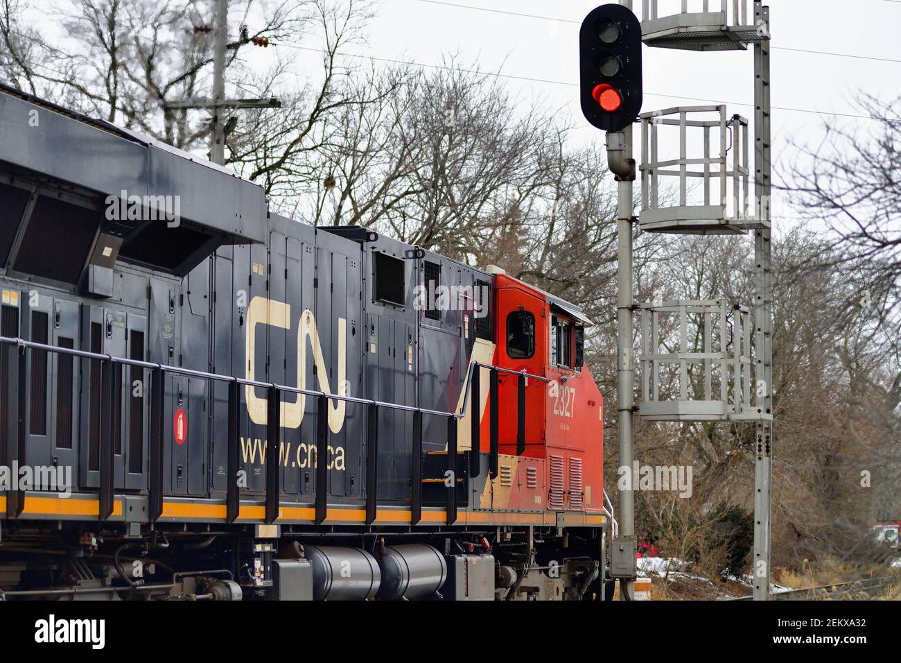 West Chicago, Illinois, USA. Eine einzelne Lokomotive der Canadian National Railway, die einen Güterzug führt, passiert ein Blocksignal. Stockfoto