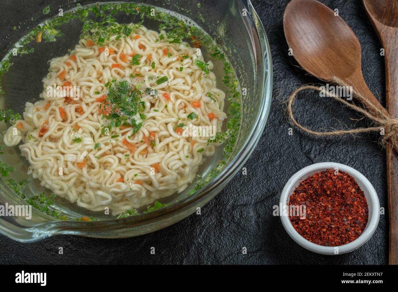 Eine Glasplatte mit leckeren Nudeln und Gewürzen auf einem Dunkler Hintergrund Stockfoto