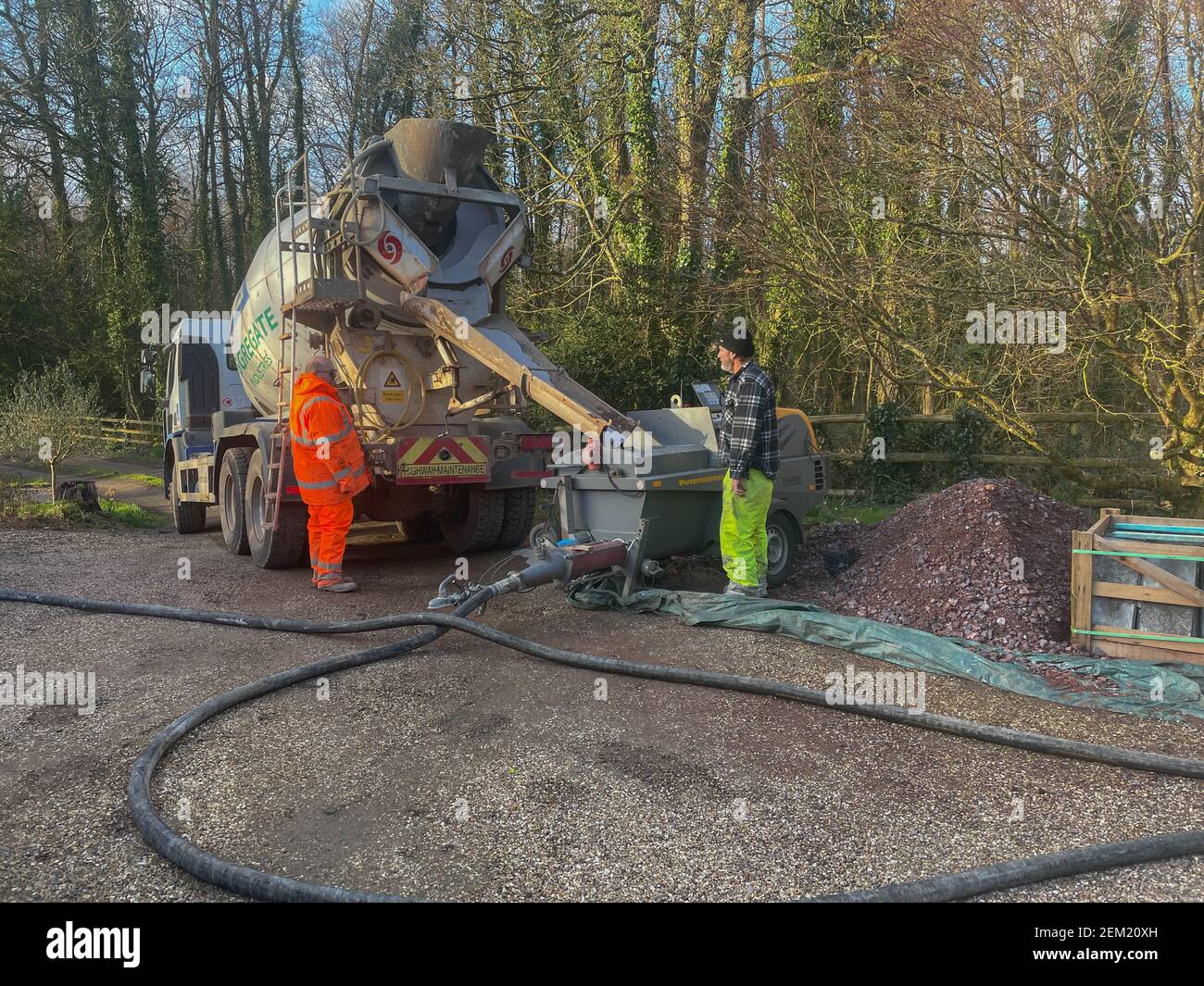 Entladen von Flüssigbodenestrich von einem Zementmischwagen in eine Durchflusspumpe auf einer Baustelle in Rural Devon, England, Großbritannien Stockfoto
