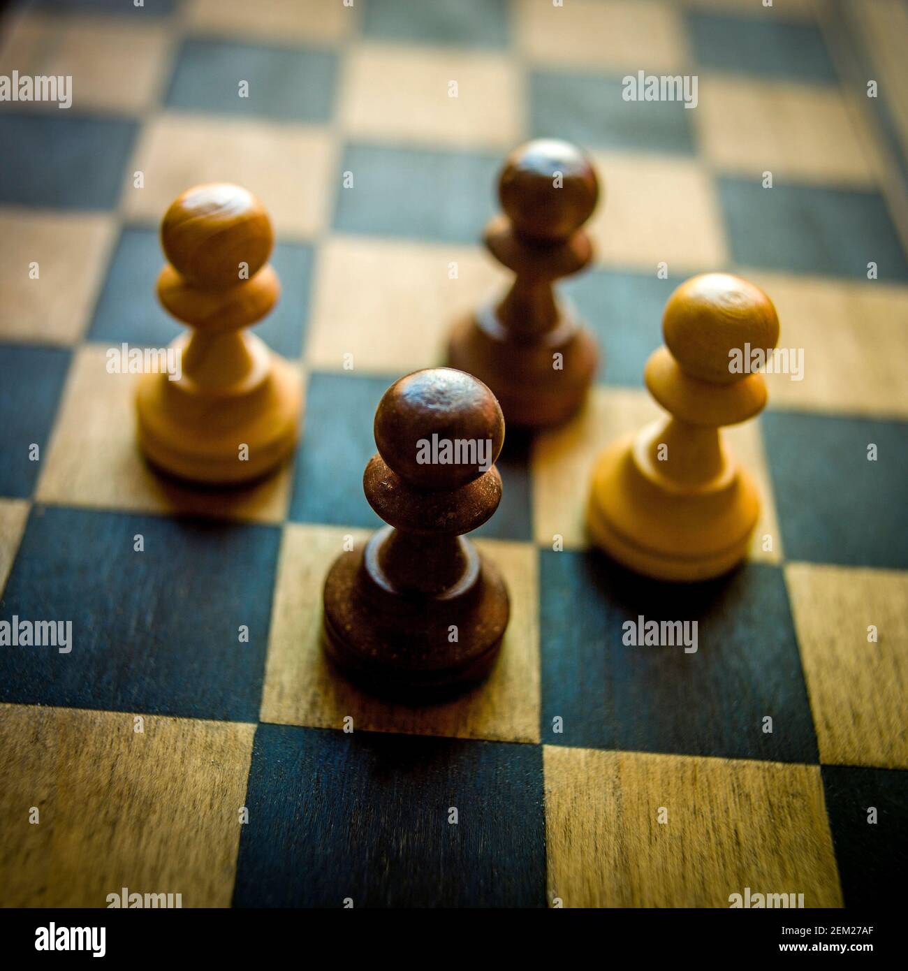 Schachfiguren in strategischer Position auf einem Holzbrett während eines intensiven Spiels Stockfoto