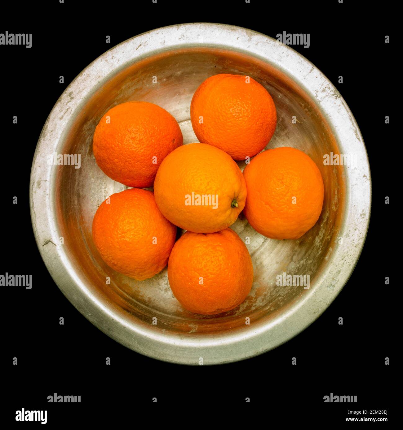 Frische Orangen in einer Edelstahlschale auf dunkler Oberfläche, die ihre leuchtende Farbe und ihren gesunden Anblick zum Ausdruck bringt Stockfoto