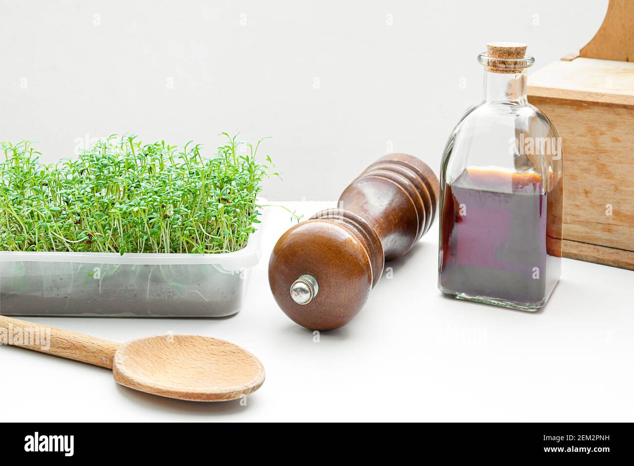 Micro Greens Brunnenkresse zu Hause gekeimt und Kürbiskernöl in einer Flasche auf dem Küchentisch, gesunde Ernährung und Superfood-Konzept Stockfoto