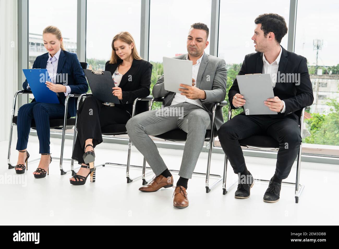 Geschäftsfrauen und Geschäftsleute halten Lebenslauf Ordner beim Warten auf Stühlen im Büro für Vorstellungsgespräch. Unternehmensgeschäft und Personalwesen Stockfoto