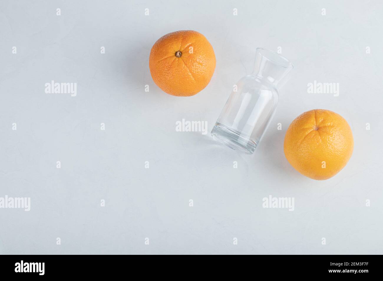 Frische Orangenfrüchte mit leerem Glaskrug Stockfoto