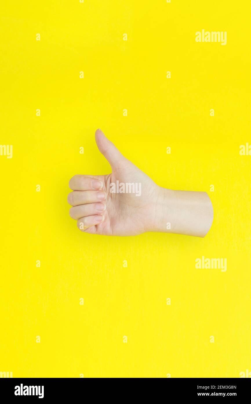 Hand zeigen wie oder gute Zeichen Erfolg und schön auf gelbem Hintergrund. Stockfoto