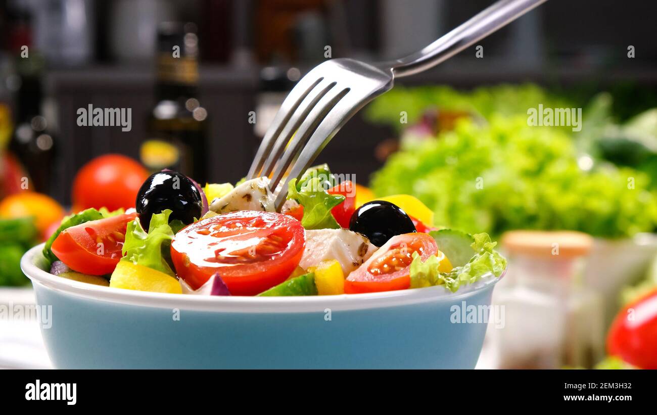 Griechischer Salat auf der Gabel, frischer Gemüsesalat mit gesunden Zutaten serviert Stockfoto