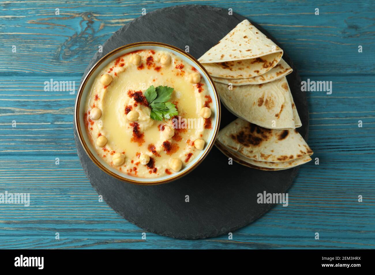 Tablett mit Schale Hummus und Pita auf Holzgrund Stockfoto