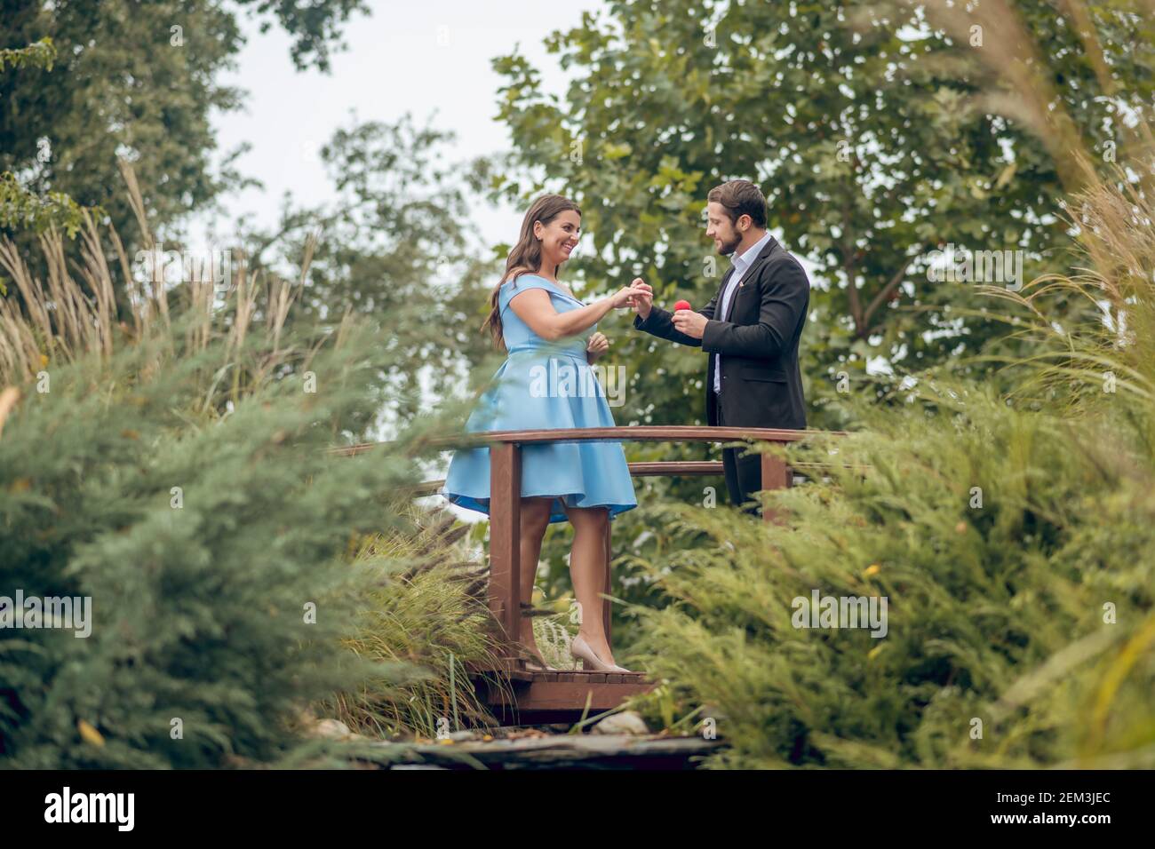 Mann legt einen Ring auf glückliche Frau Stockfoto