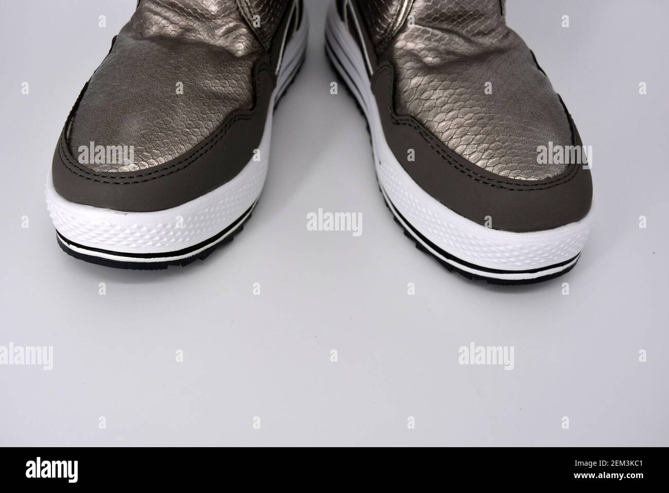 Wasserdichte Damenstiefel im Winter. Silberne, bronzene warme Stiefel mit  warmem Füllstoff. Sport warme Schuhe auf einer sehr dicken weißen Plattform  Stockfotografie - Alamy