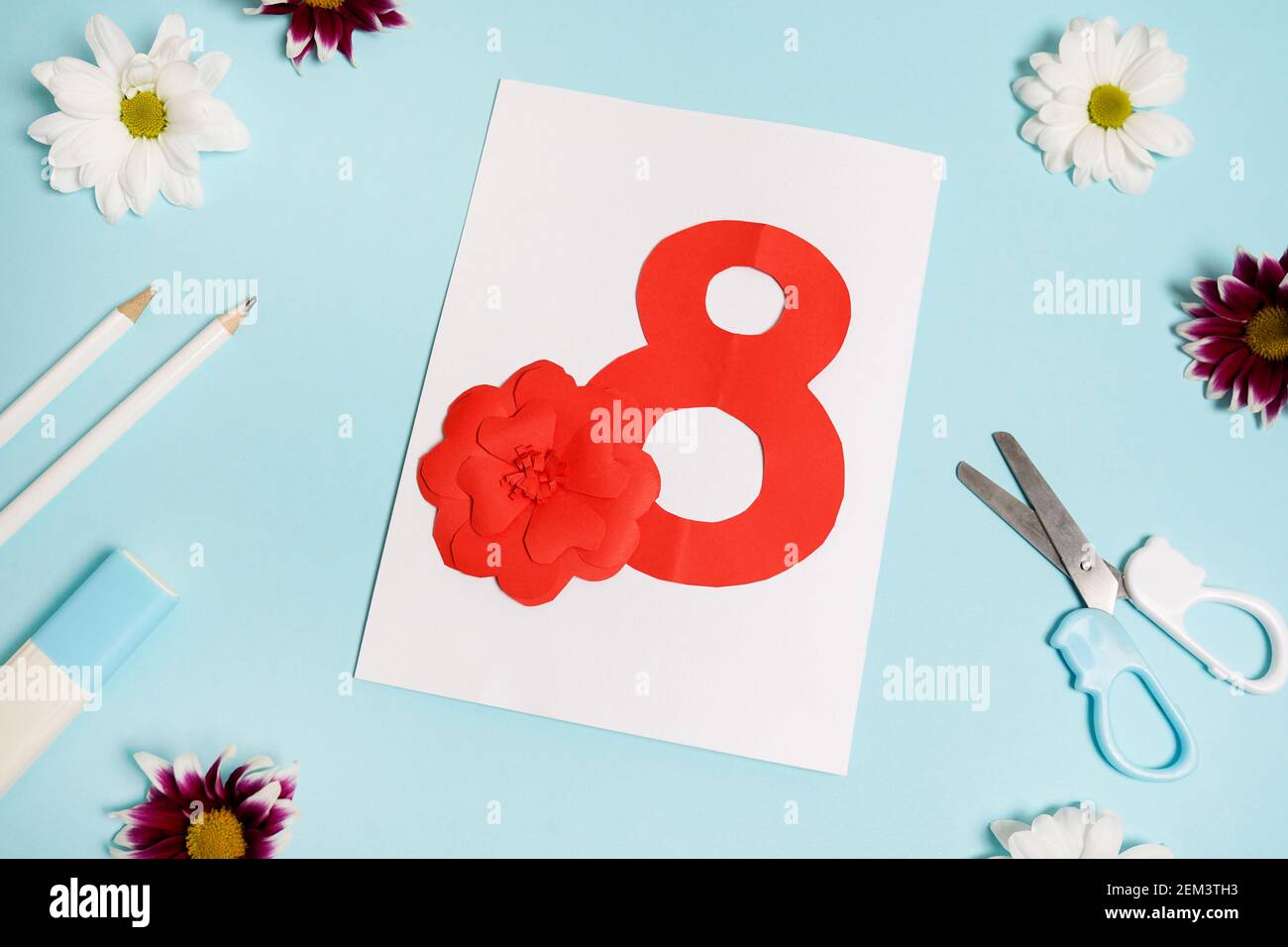 Schöne Grußkarte von einem Kind für Muttertag, März 8, Handgefertigte Karte mit Nummer acht auf blauem Tisch mit Blumen. Kinder Workshop Konzept. Oben Stockfoto