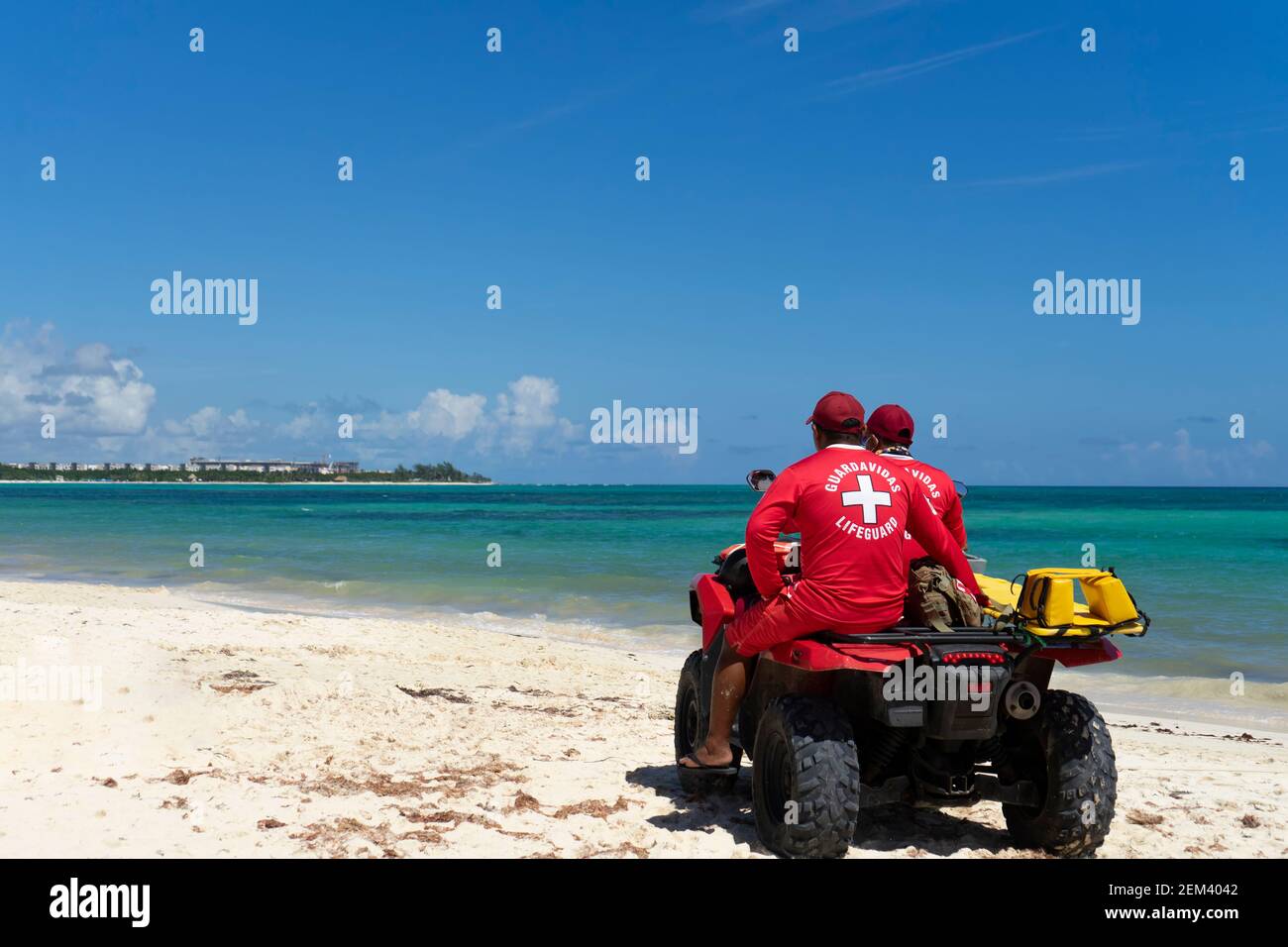 Zwei Rettungsschwimmer auf einem Quad-Bike beobachten das Meer, um die Sicherheit des Strandes und der Badegäste zu überwachen. Konzept von Urlaub und Schutz in Mexiko Stockfoto
