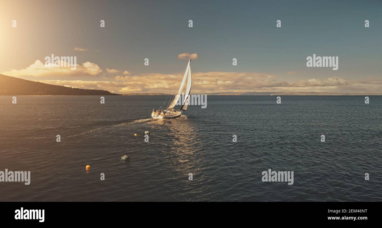 Aerial Yacht Regatta Rennen auf offener See. Weißes Segelboot bei Sommersonnenlicht Tag. Erstaunliche Seestape des Ozeans Wasser bei Sonnenreflexionen. Ruhiges Wasser im Kino Entspannen Sie sich und ruhige Wasserlandschaft Stockfoto