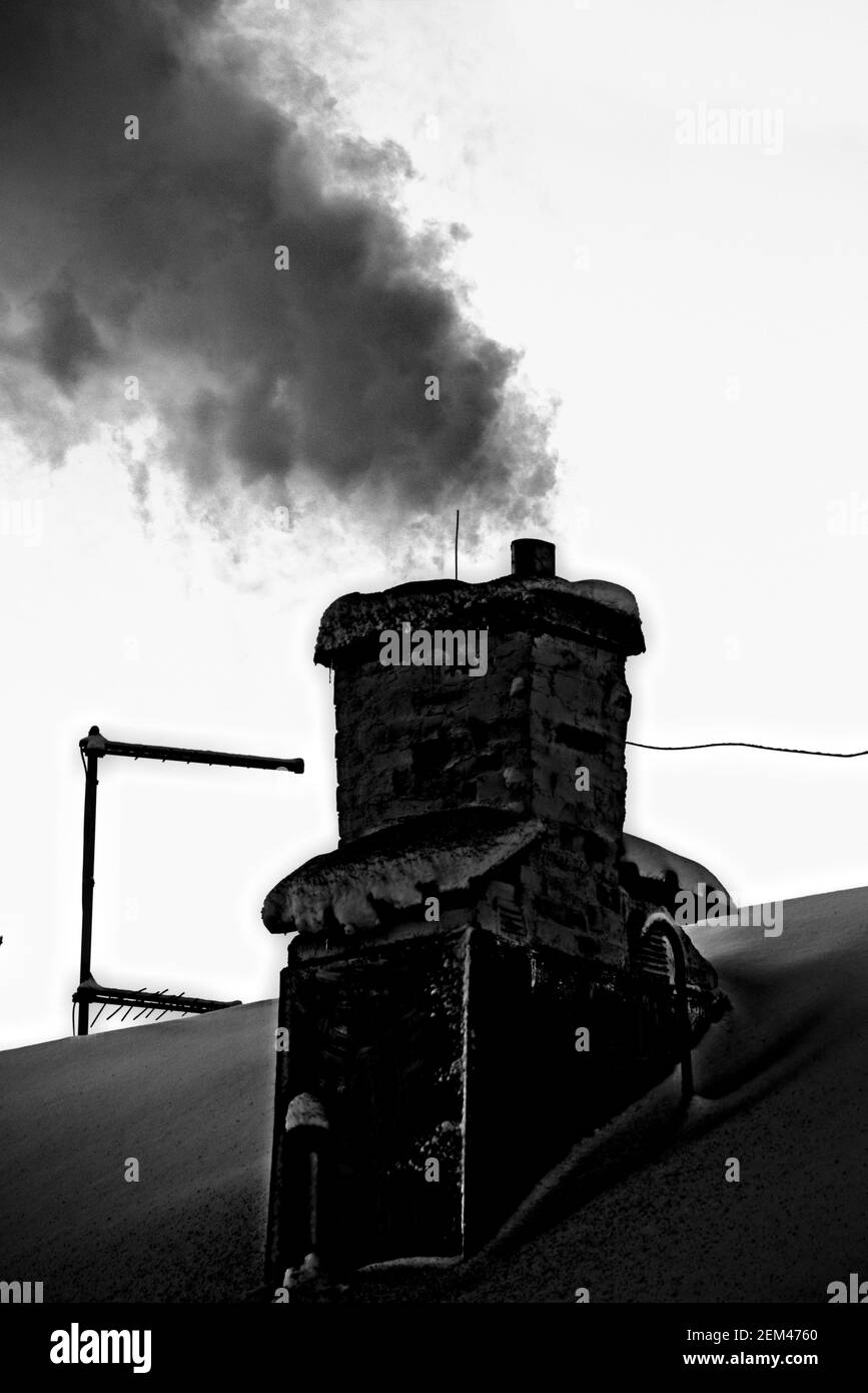 Alter und rußiger Kamin mit viel Rauch. Stockfoto