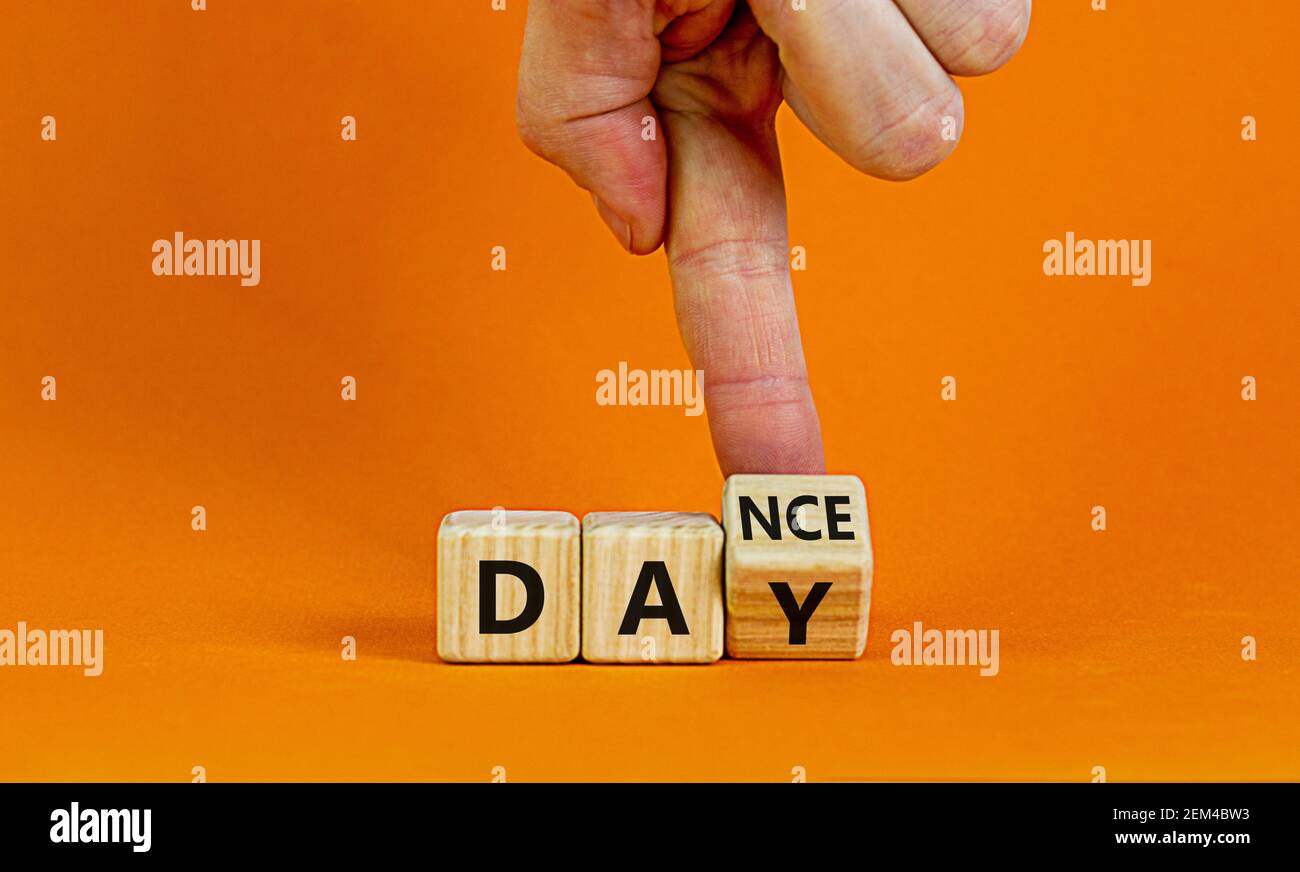 Symbol für den Internationalen Tanztag. Tänzer dreht Würfel mit den Worten 'Tanz Tag'. Schöner orangefarbener Tisch, orangefarbener Hintergrund, Kopierbereich. Internationaler Tanz Stockfoto