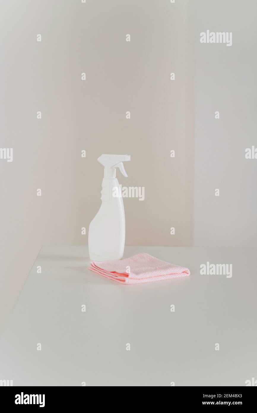 Weiße Plastikflasche und rosa reg auf weißem Küchentisch. Stockfoto