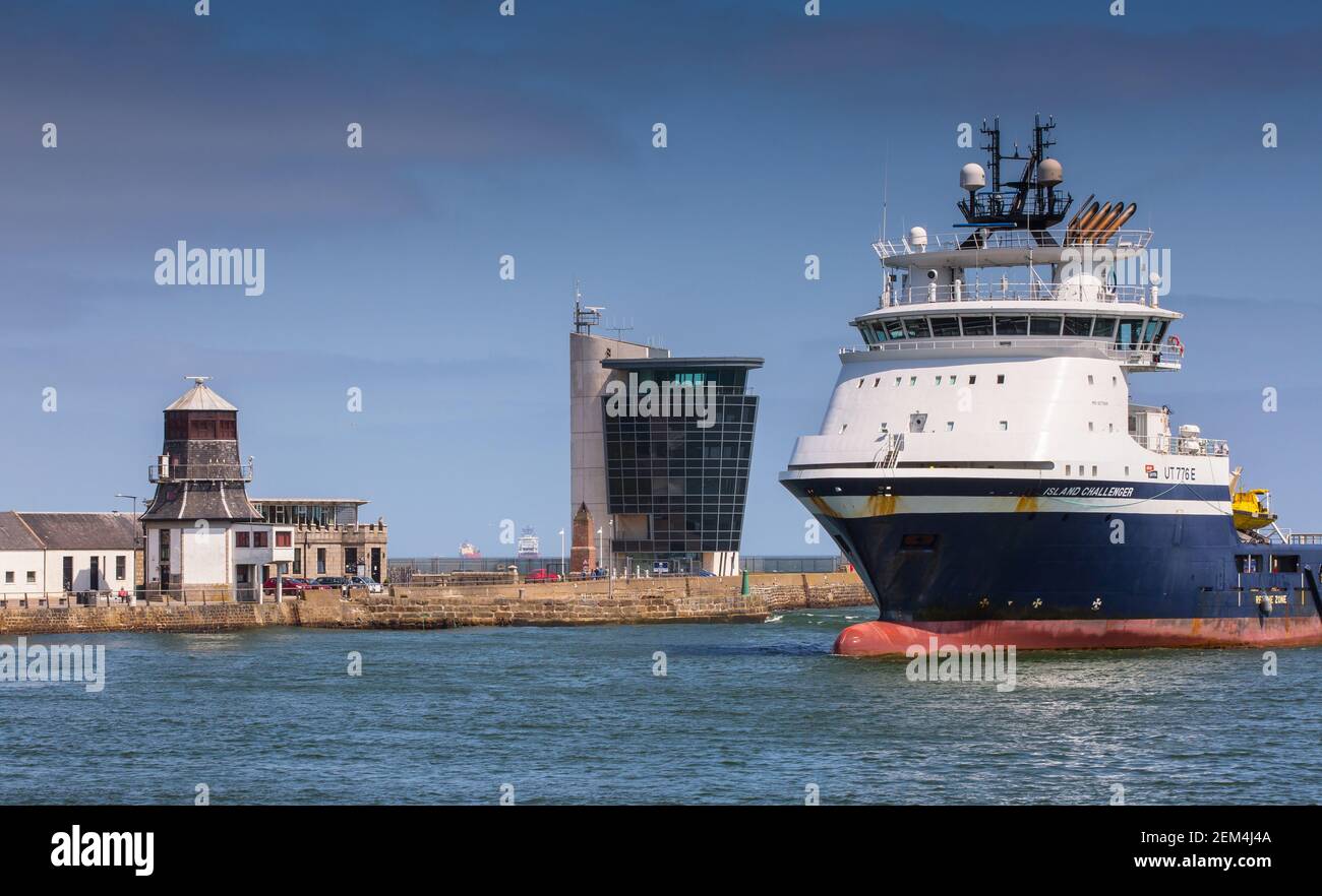 Ein Ölversorgungsschiff passiert den Hafenkontrollturm (rechts) mit dem alten Roundhouse auf der linken Seite, in Aberdeen, Schottland Stockfoto