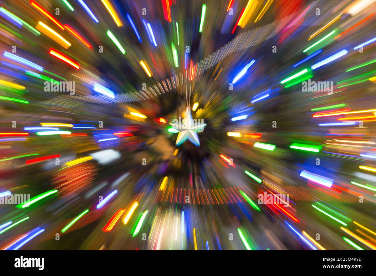 Ein Stern, der von bunten Lichtern umgeben ist, scheint zu zoomen Stockfoto