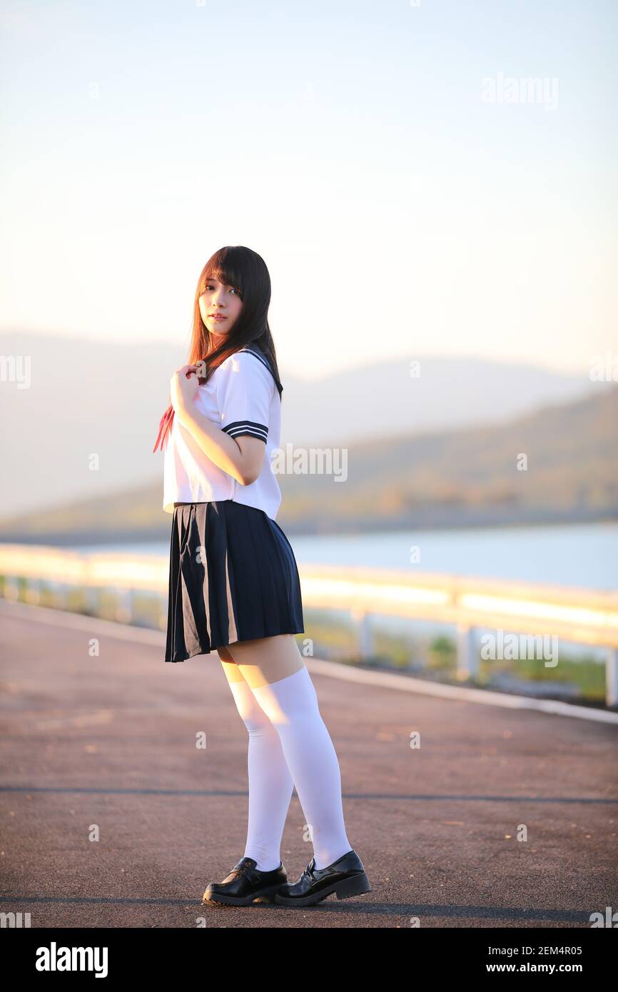 Portrait der japanischen Schule Mädchen uniform Lächeln mit Gehweg und Fluss Stockfoto