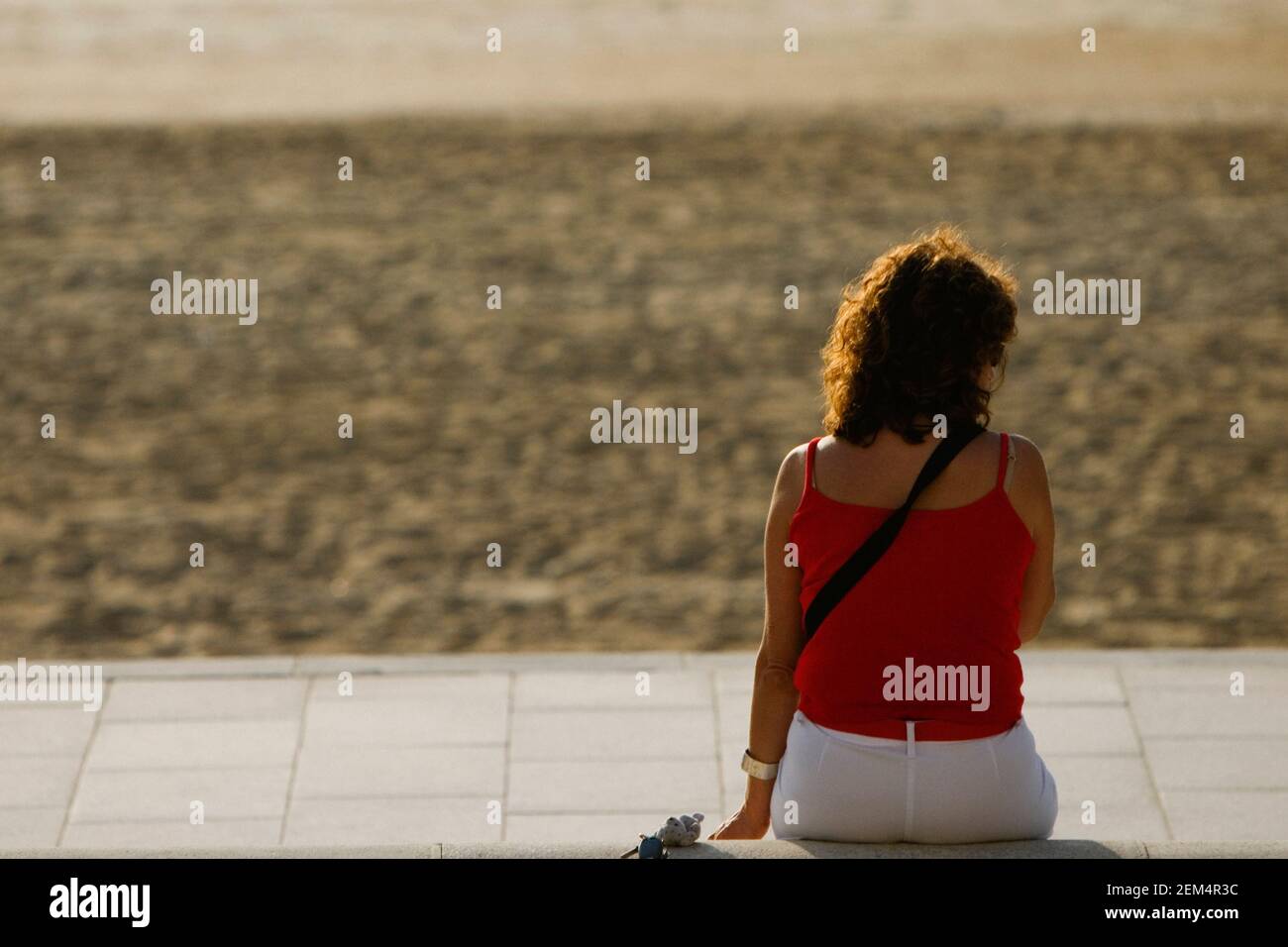 Rückansicht einer Frau am Strand sitzen Stockfoto
