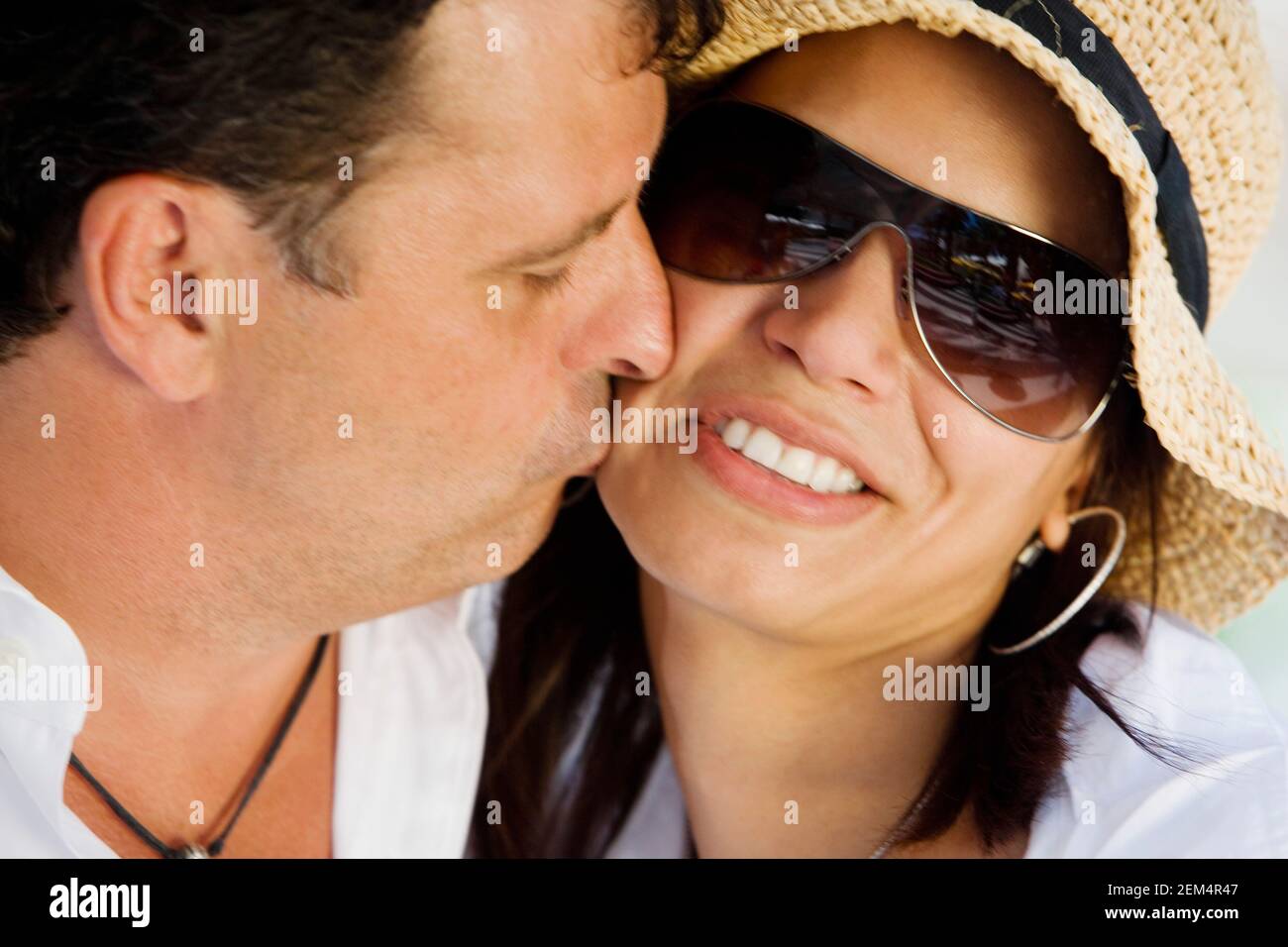 Nahaufnahme eines Mannes mit mittlerem Erwachsenen, der einen mittleren Erwachsenen küsst Frau auf der Wange Stockfoto