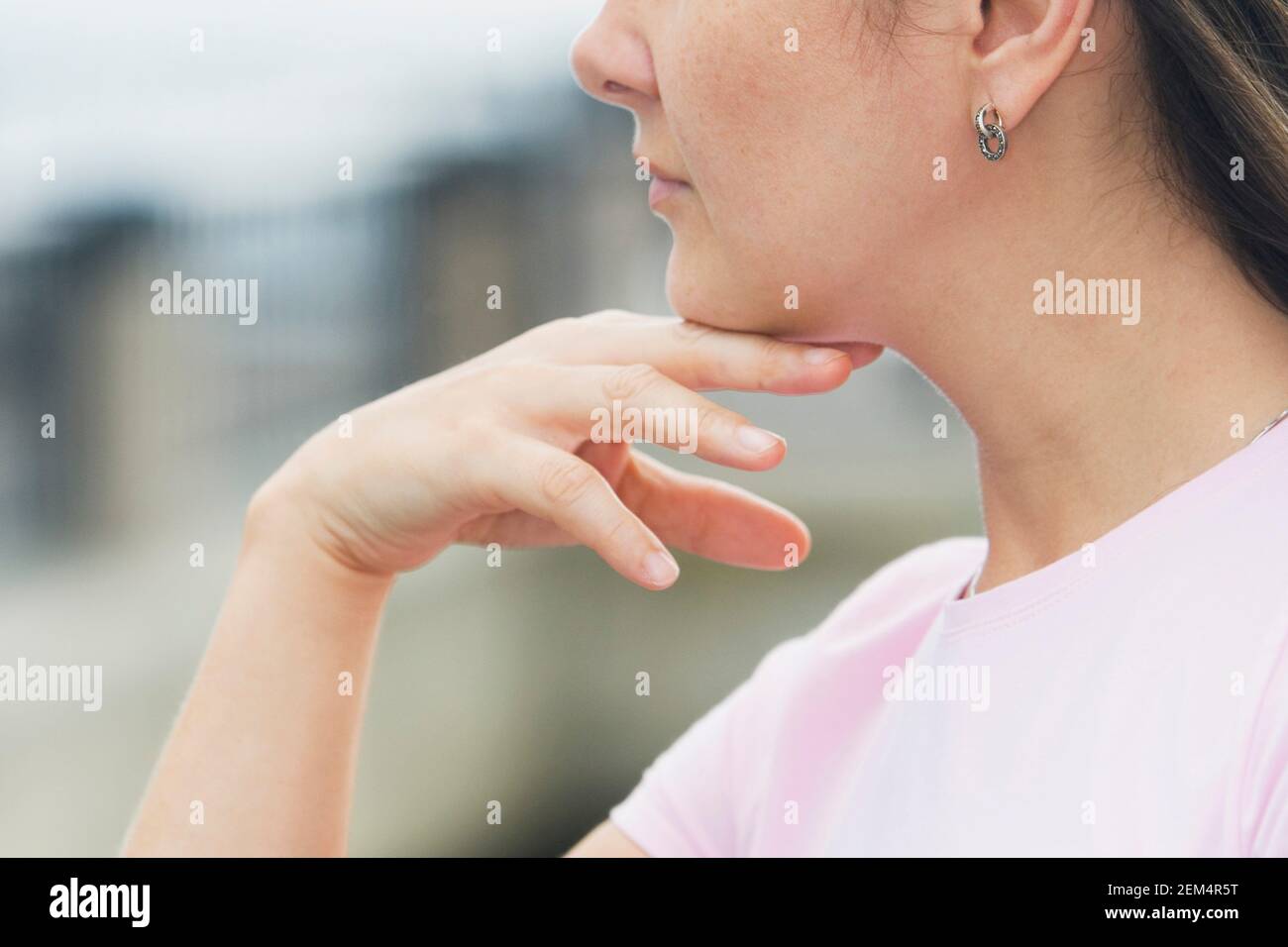 Nahaufnahme einer jungen Frau mit der Hand am Kinn denken Stockfoto