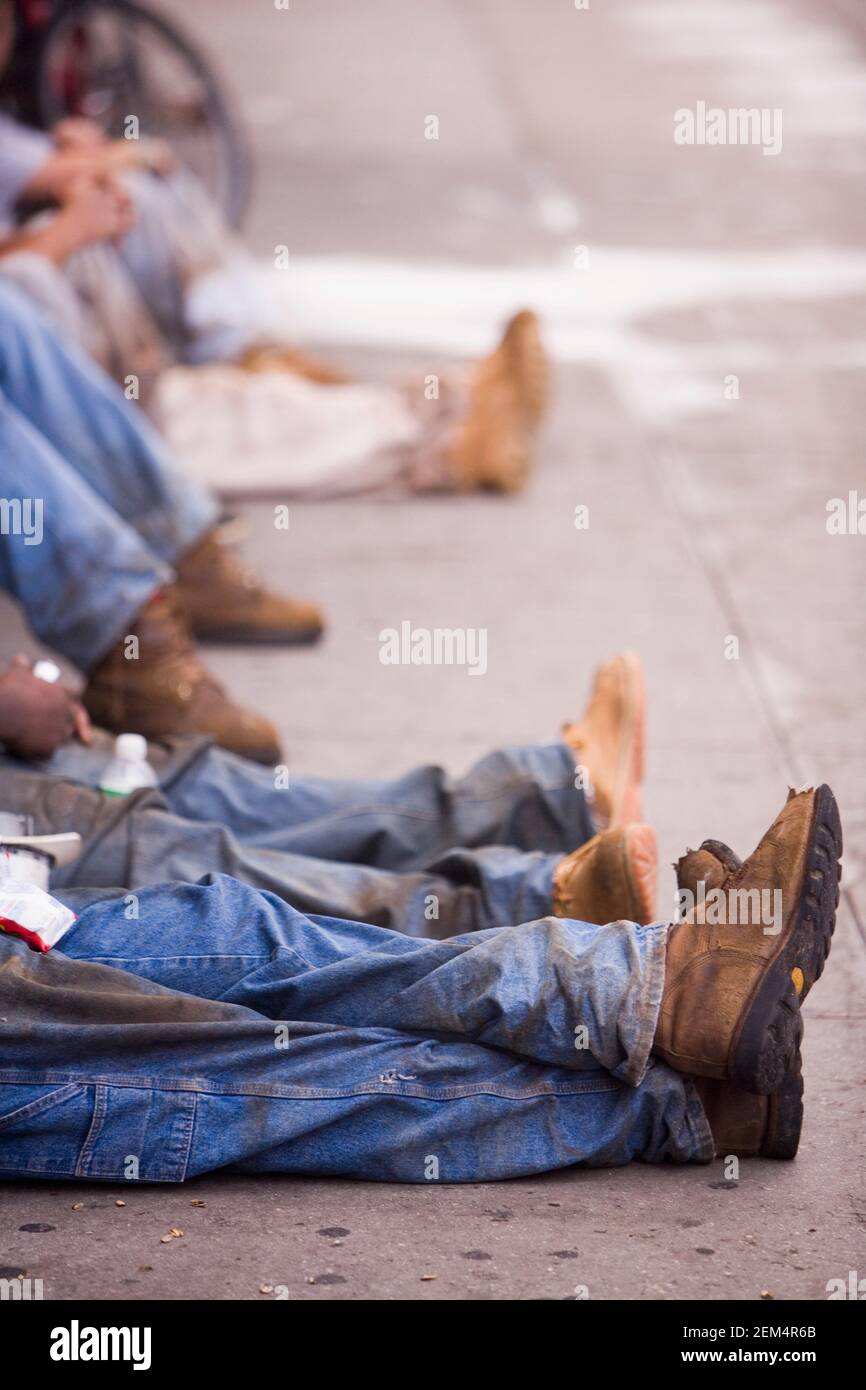 Niedrige Ansicht einer Gruppe von Personen, die auf sitzen Die Straße Stockfoto