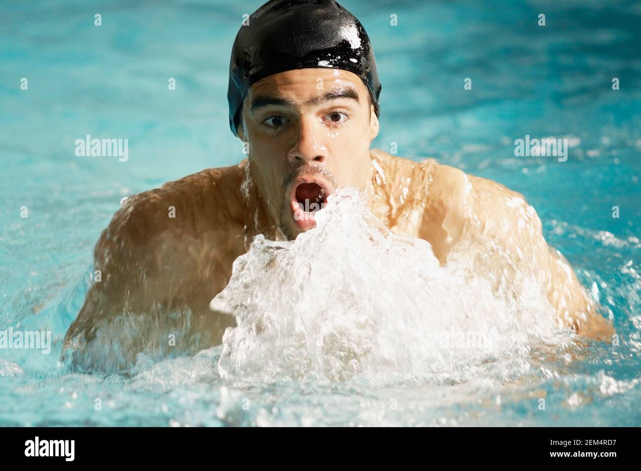 Porträt eines jungen Mannes, der in einem Schwimmbad schwimmt Stockfoto