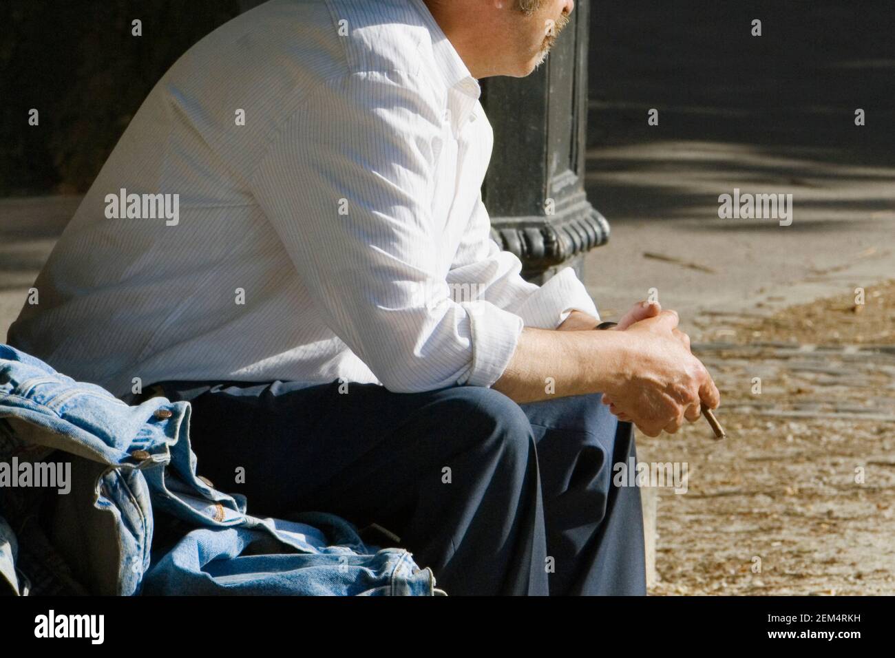 Seitenprofil eines Mannes, der eine Zigarette hält Stockfoto