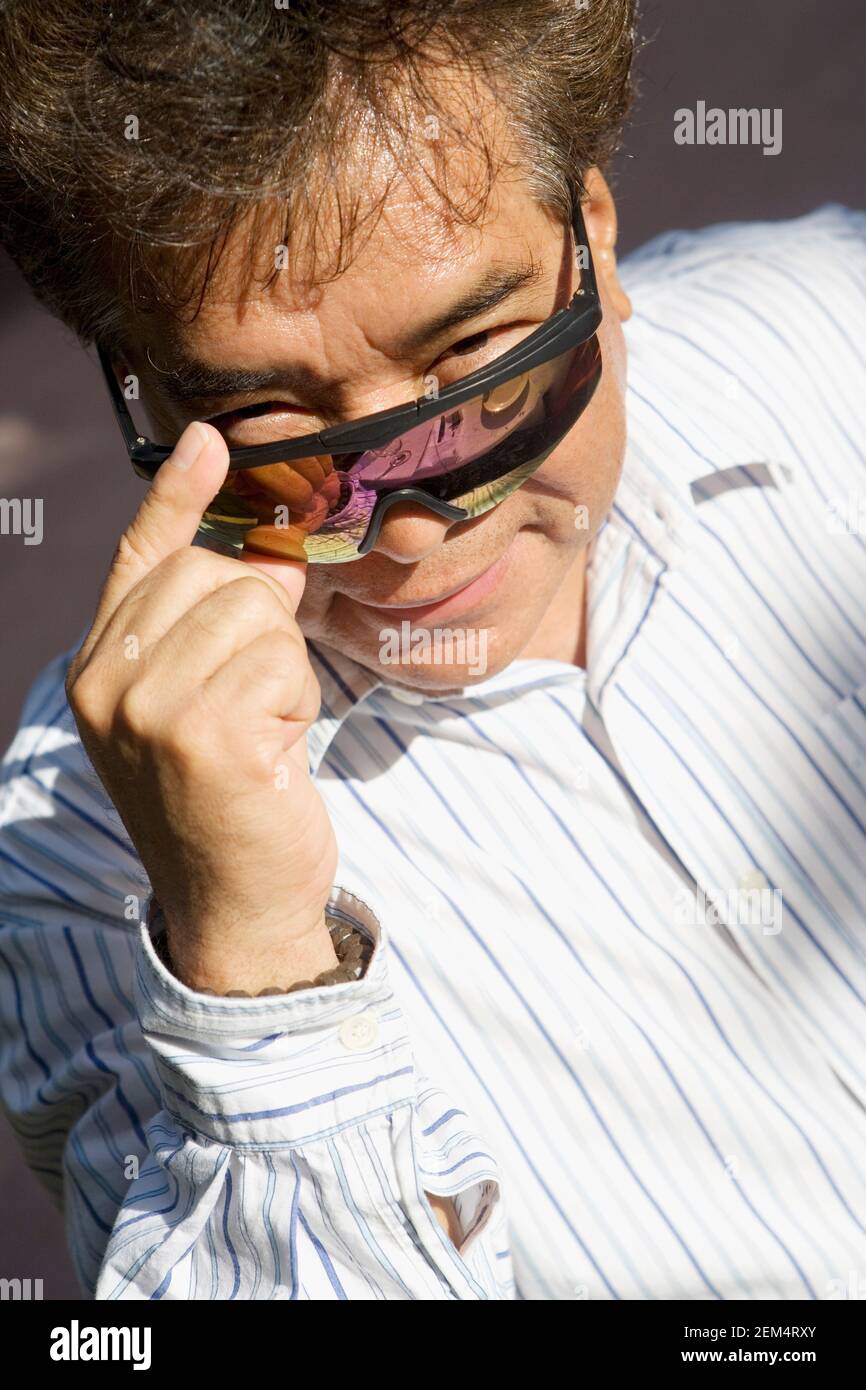 Porträt eines reifen Mannes, der über seine Sonnenbrille guckt Stockfoto