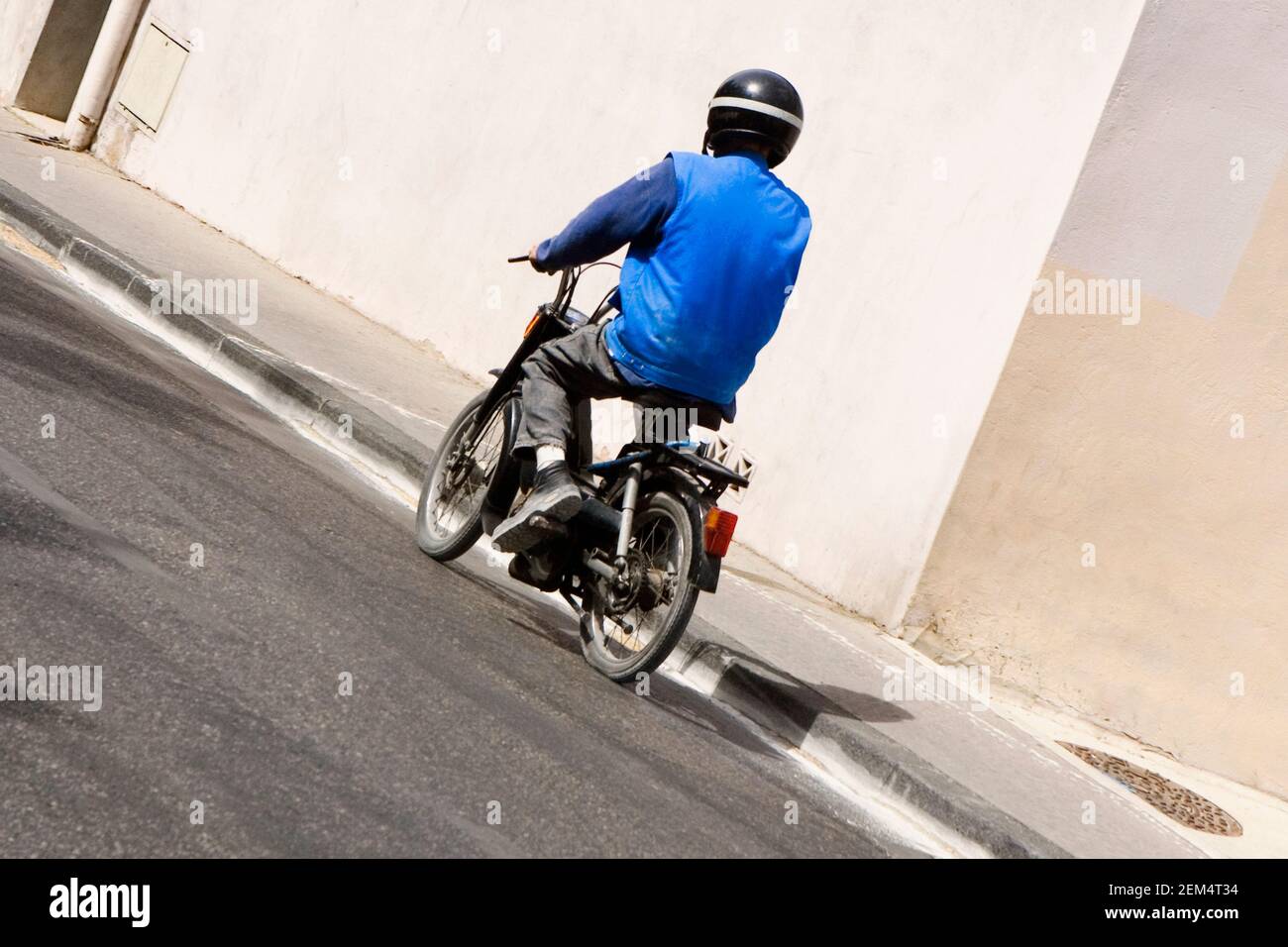 Rückansicht eines Mannes auf einem Moped Stockfoto