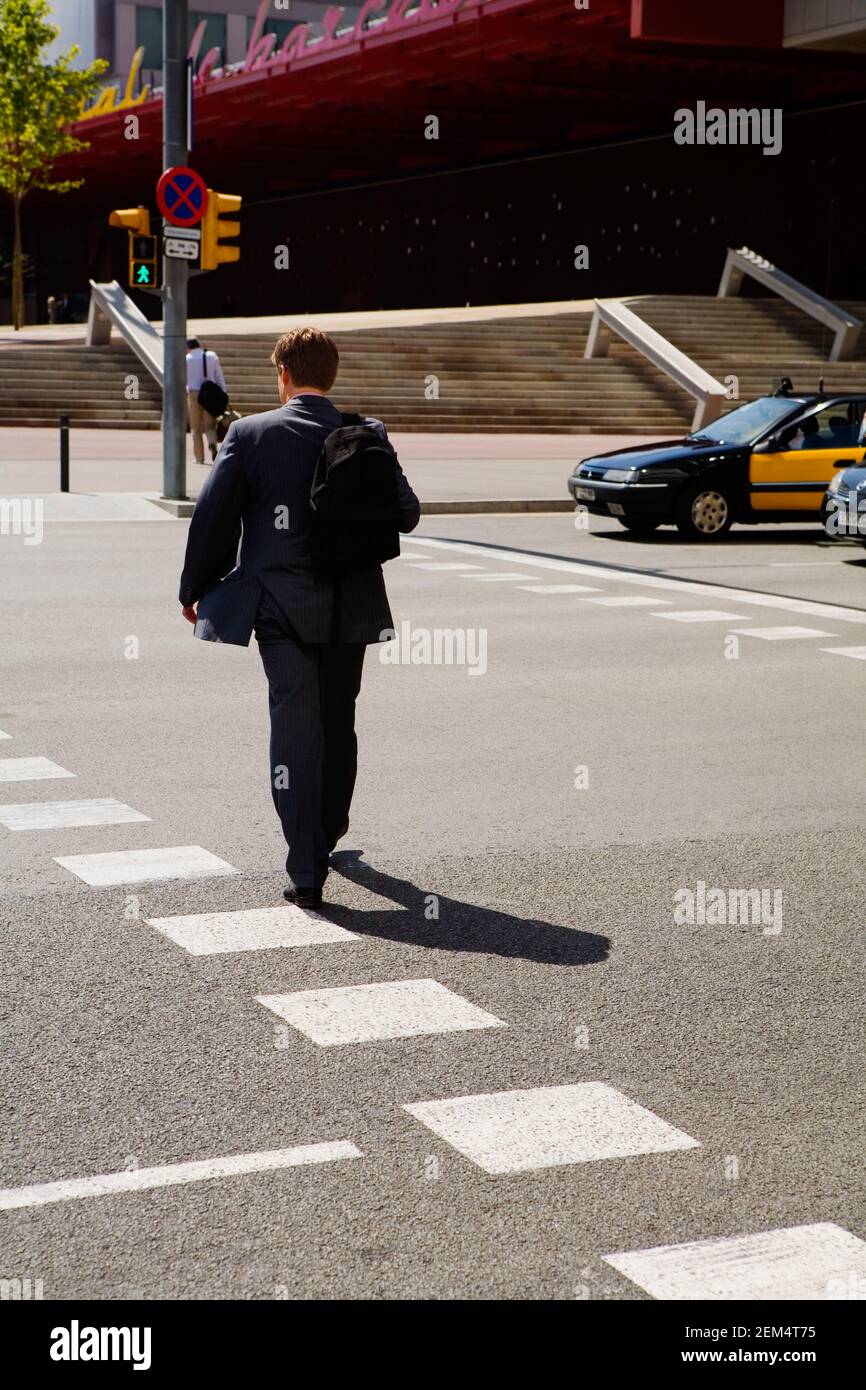 Rückansicht eines Mannes, der eine Tasche trägt und läuft Unterwegs Stockfoto
