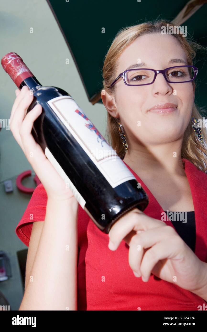 Porträt einer jungen Frau mit einer roten Flasche Wein Stockfoto