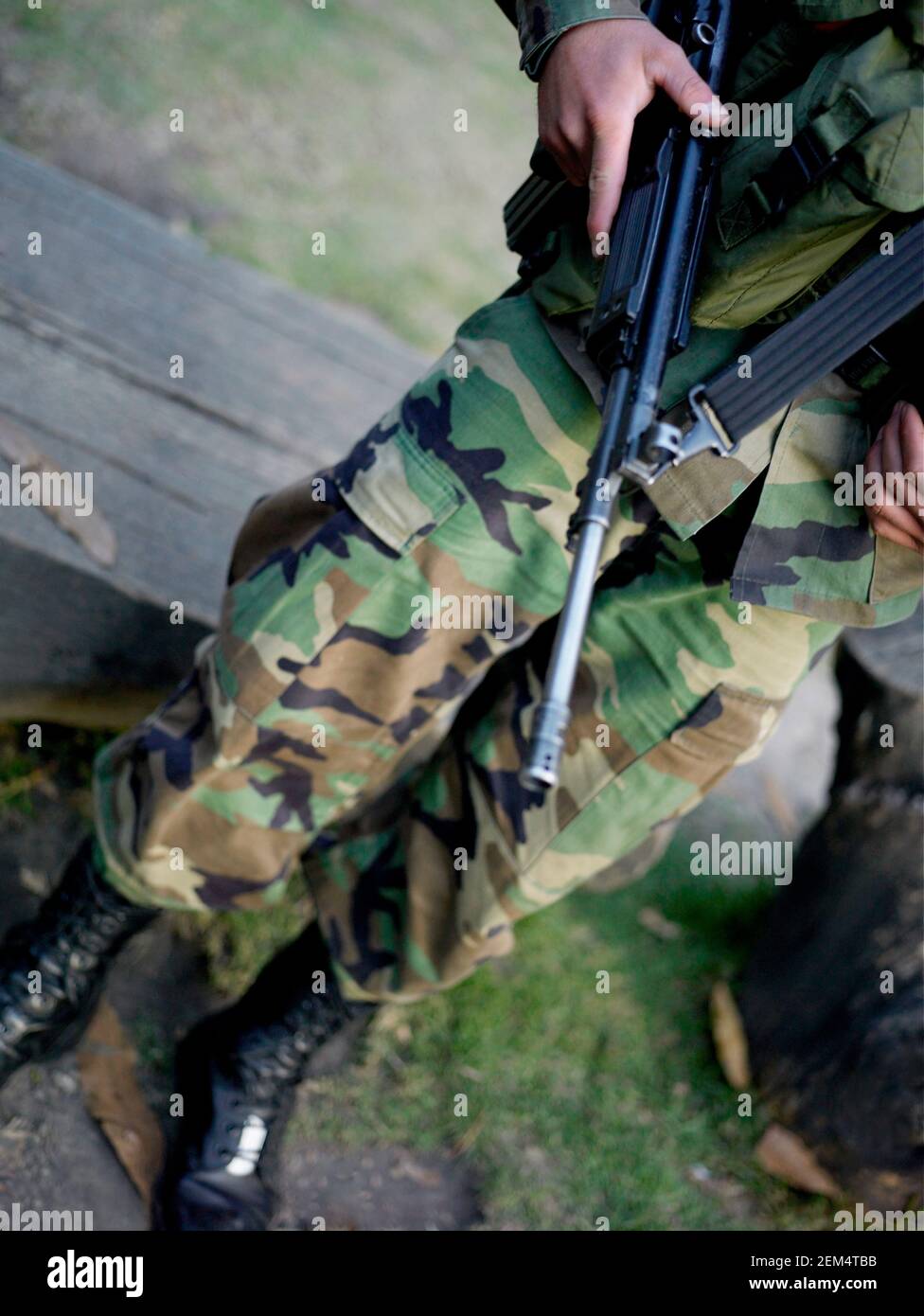 Low-Section-Ansicht eines Soldaten der Armee hält seine Maschine Pistole Stockfoto