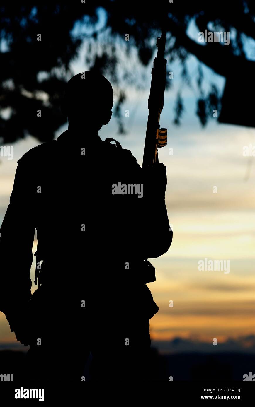 Silhouette eines Soldaten mit einem Maschinengewehr Stockfoto