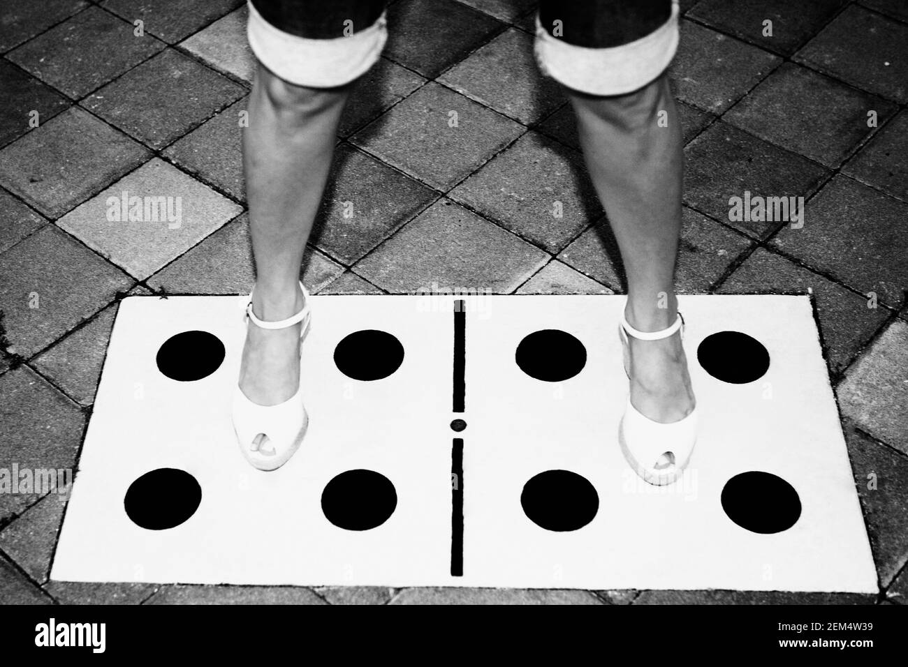 Niedrige Schnittansicht einer Frau stehend mit ihre Beine auseinander auf Würfel auf den Boden gezeichnet Stockfoto