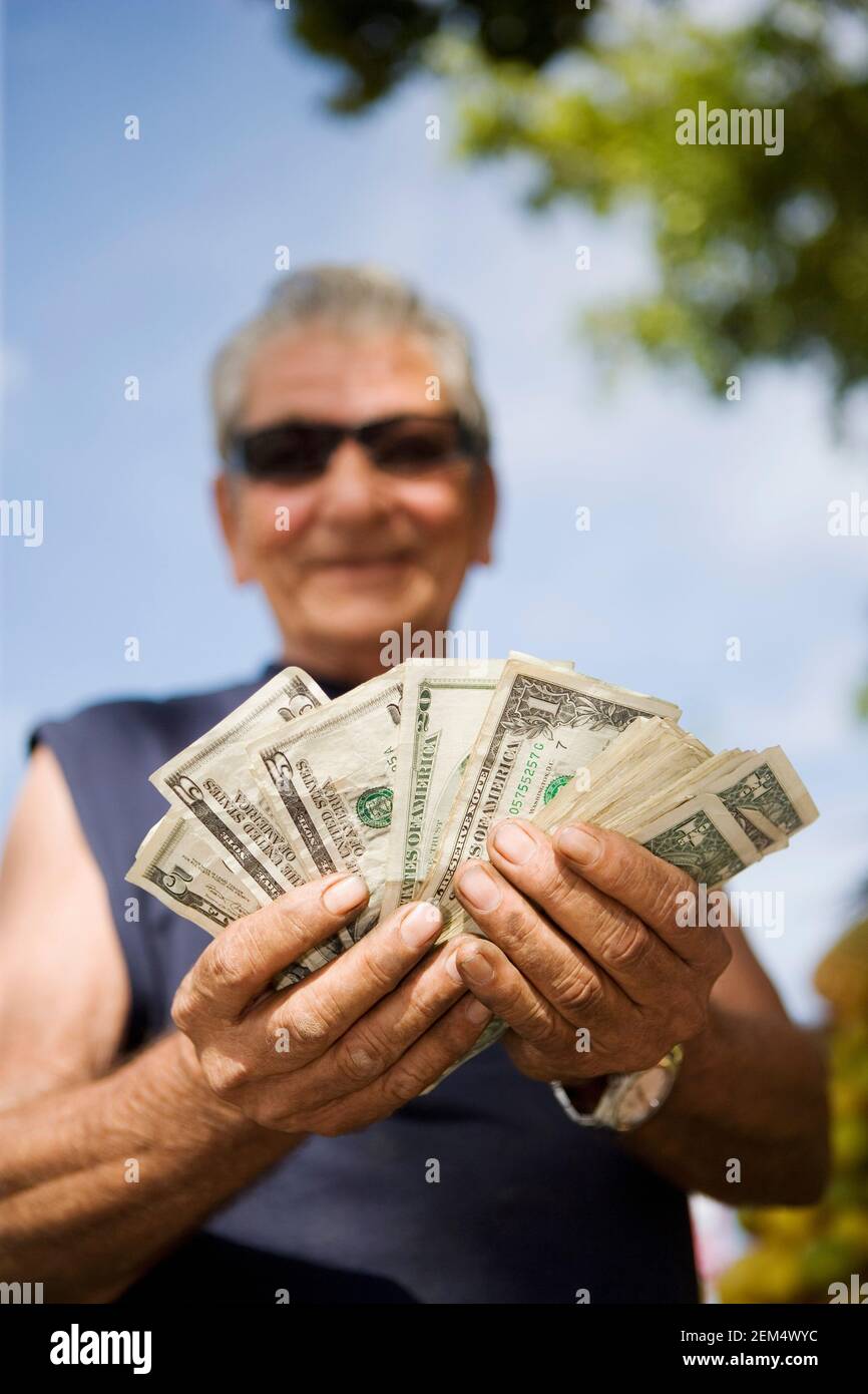 Nahaufnahme eines älteren Mannes, der amerikanische Dollarscheine zählt Stockfoto