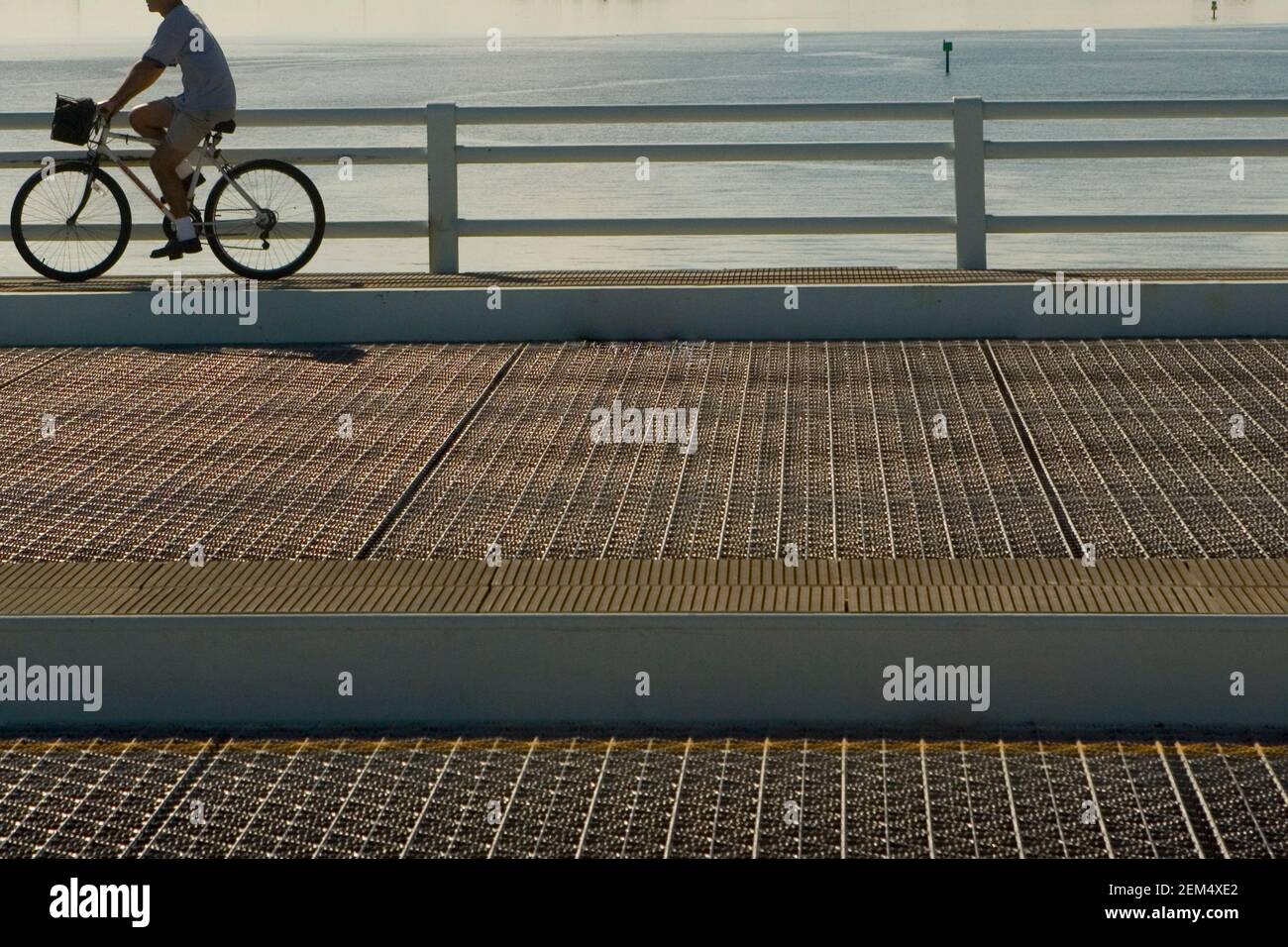 Seitenprofil eines Mannes, der ein Fahrrad auf einem fährt Brücke Stockfoto