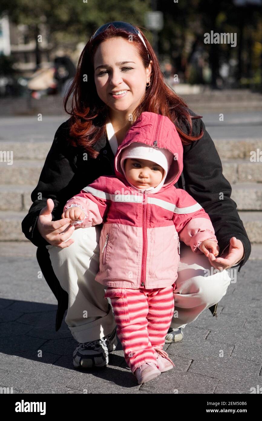 Mittlere Erwachsene Frau lächelt mit ihrem Baby Mädchen Stockfoto