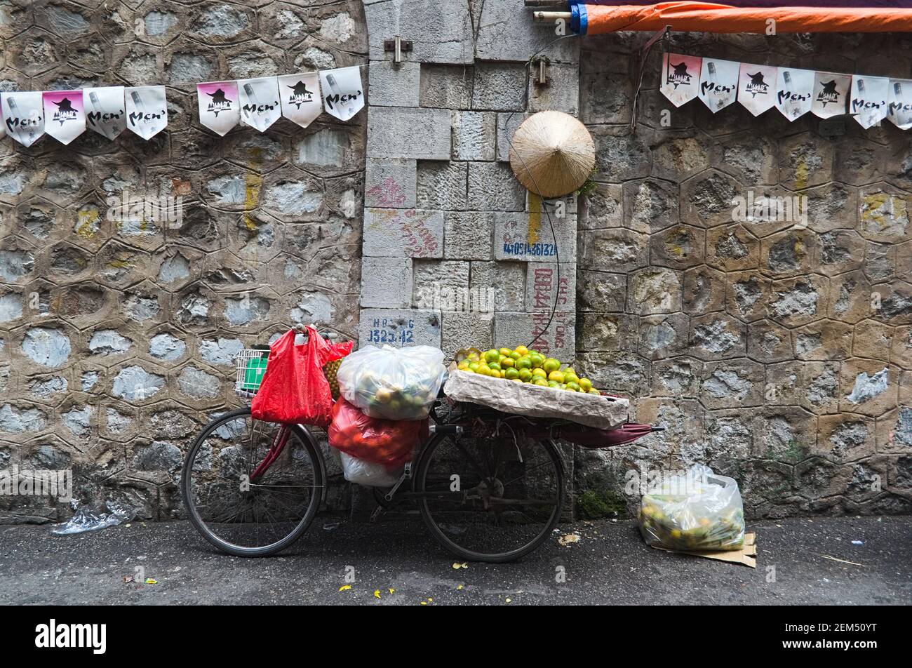 Hanoi, Vietnam - September, 2015: Altes Fahrrad mit Orangen und Taschen an der Wand auf dem Straßenmarkt Stockfoto