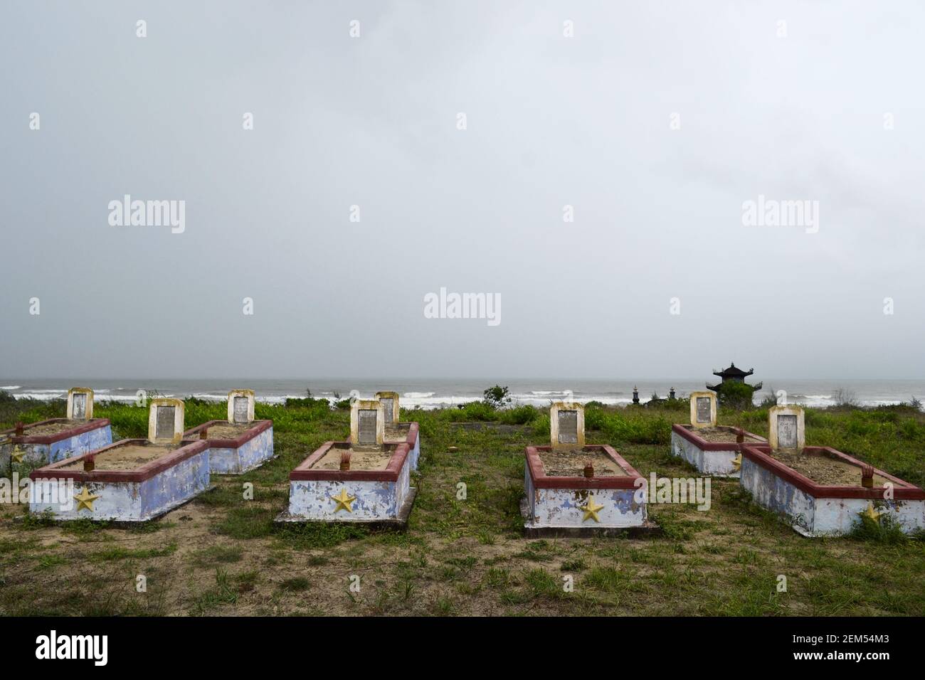 Friedhof des Vietnamkrieges mit alten verwitterten Grabsteinen in der Nähe eines Strandes in lang Co. Alte militärische Beerdigung an der Küste nahe dem Meer, Stockfoto