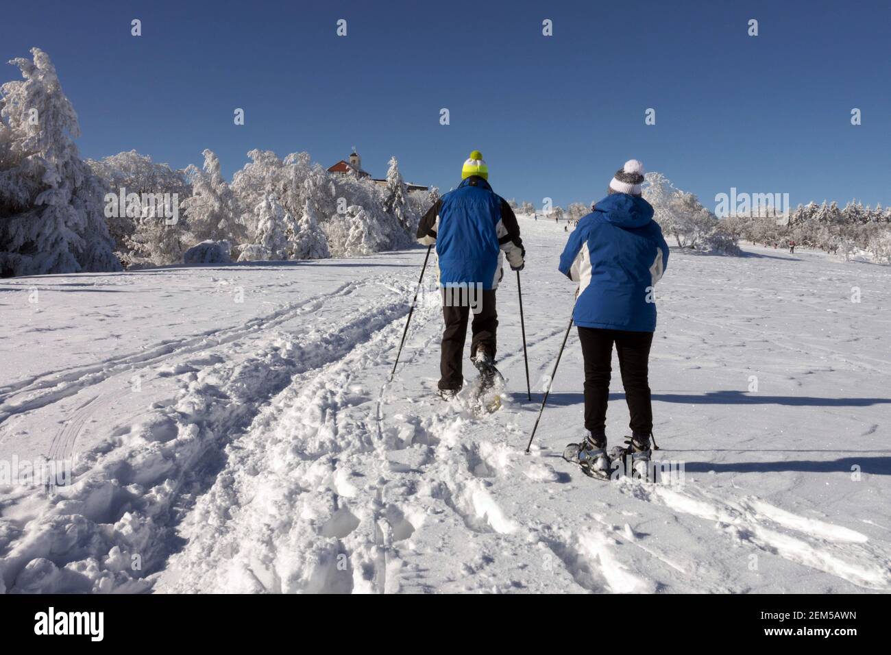 Seniorenpaar Wandern Winter Schneeschuhe Europäische Senioren Training gesunde Lebensweise Senioren Winter Wanderstöcke Paar Stockfoto