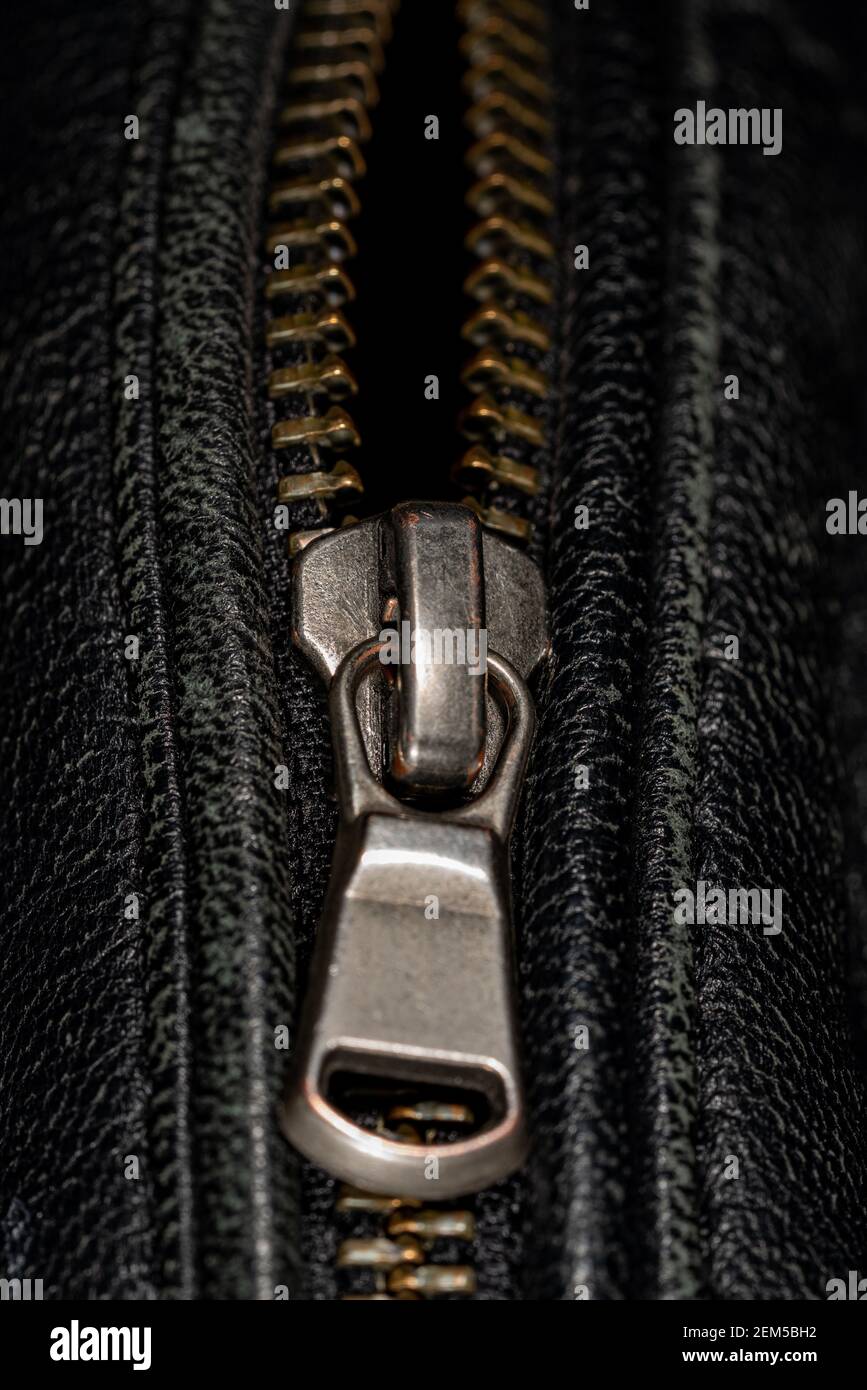 Detail der Verriegelung Reißverschluss auf schwarzem Leder Jacke. Nahaufnahme der Makro-Aufnahme mit lokalem Fokus. Vertikale Makrofotografie. Stockfoto