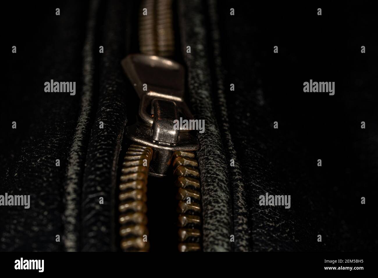 Detail der Verriegelung Reißverschluss auf schwarzem Leder Jacke. Nahaufnahme der Makro-Aufnahme mit lokalem Fokus. Vertikale Makrofotografie. Stockfoto