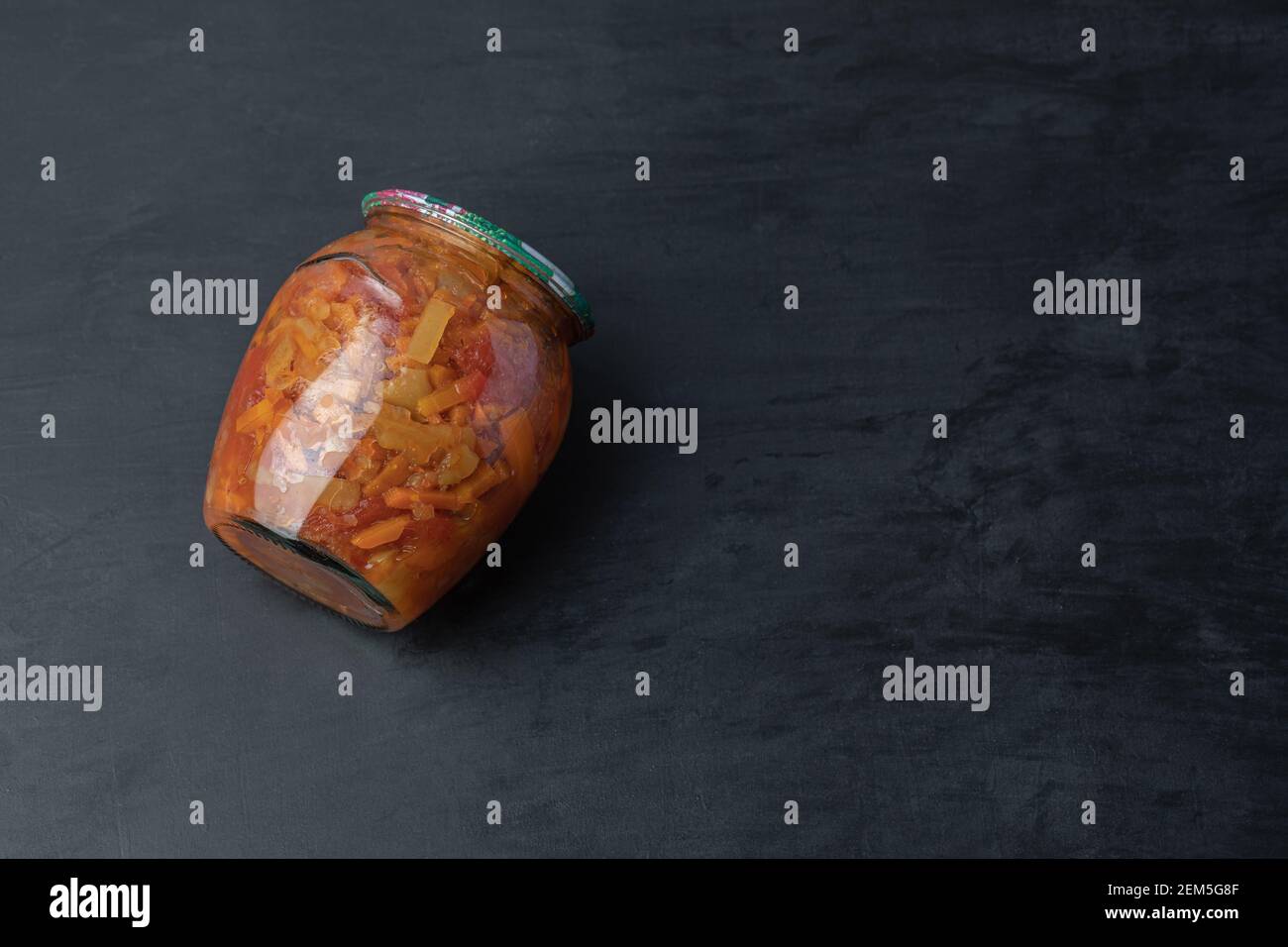 Ein Glas mit gemischtem Gemüse auf schwarzem Hintergrund Stockfoto