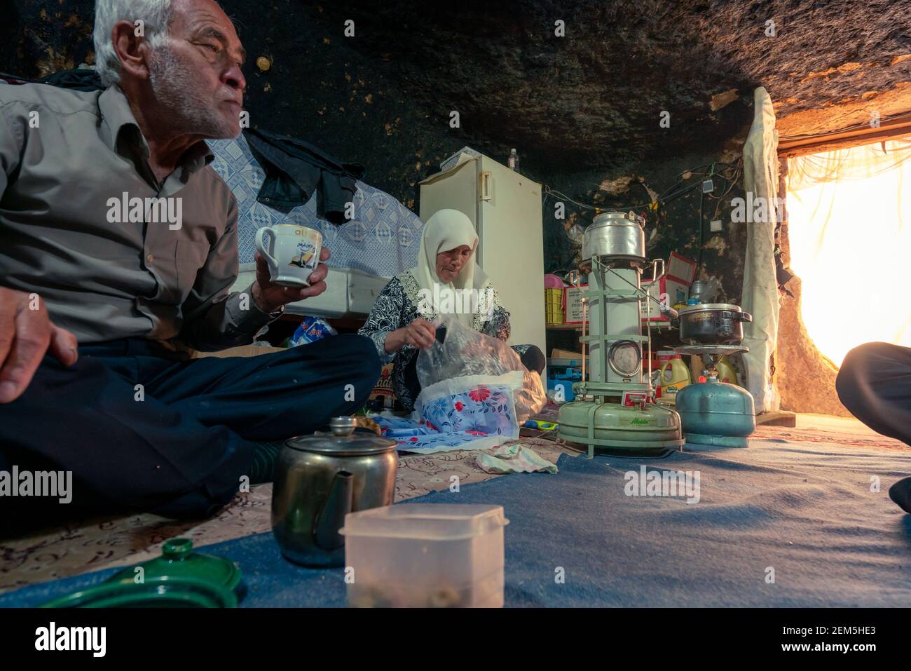 Altes iranisches Paar in ihrer bescheidenen Höhle zu Hause, die Vorbereitung für das Abendessen. Mahan, Iran. Stockfoto