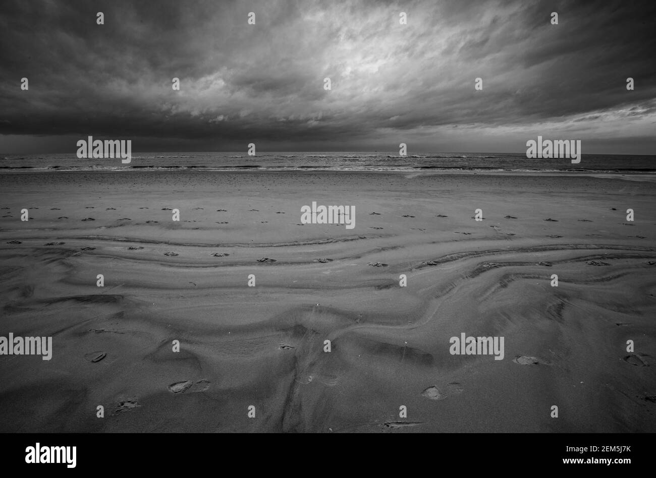 Einfache Landschaft. Ein Bild von einem einfachen einsamen Strand mit seinen vielen Konturen von Sand durch die Gezeiten links. Stockfoto