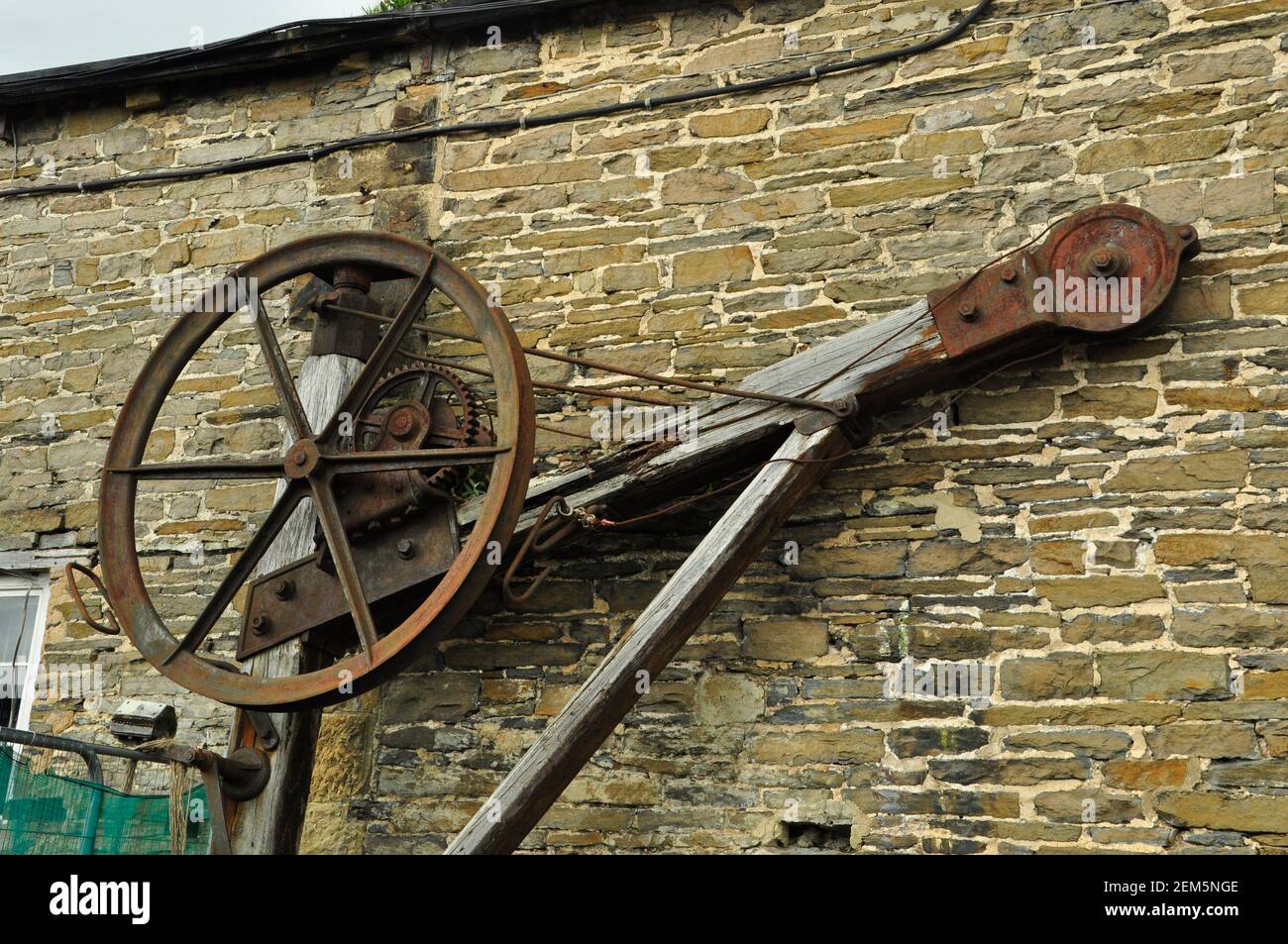 Die Überreste eines alten Eisenbahnkran. An der Wand des Bahnhofsgebäudes in Leyburn in Yorkshire. England.Vereinigtes Königreich Stockfoto