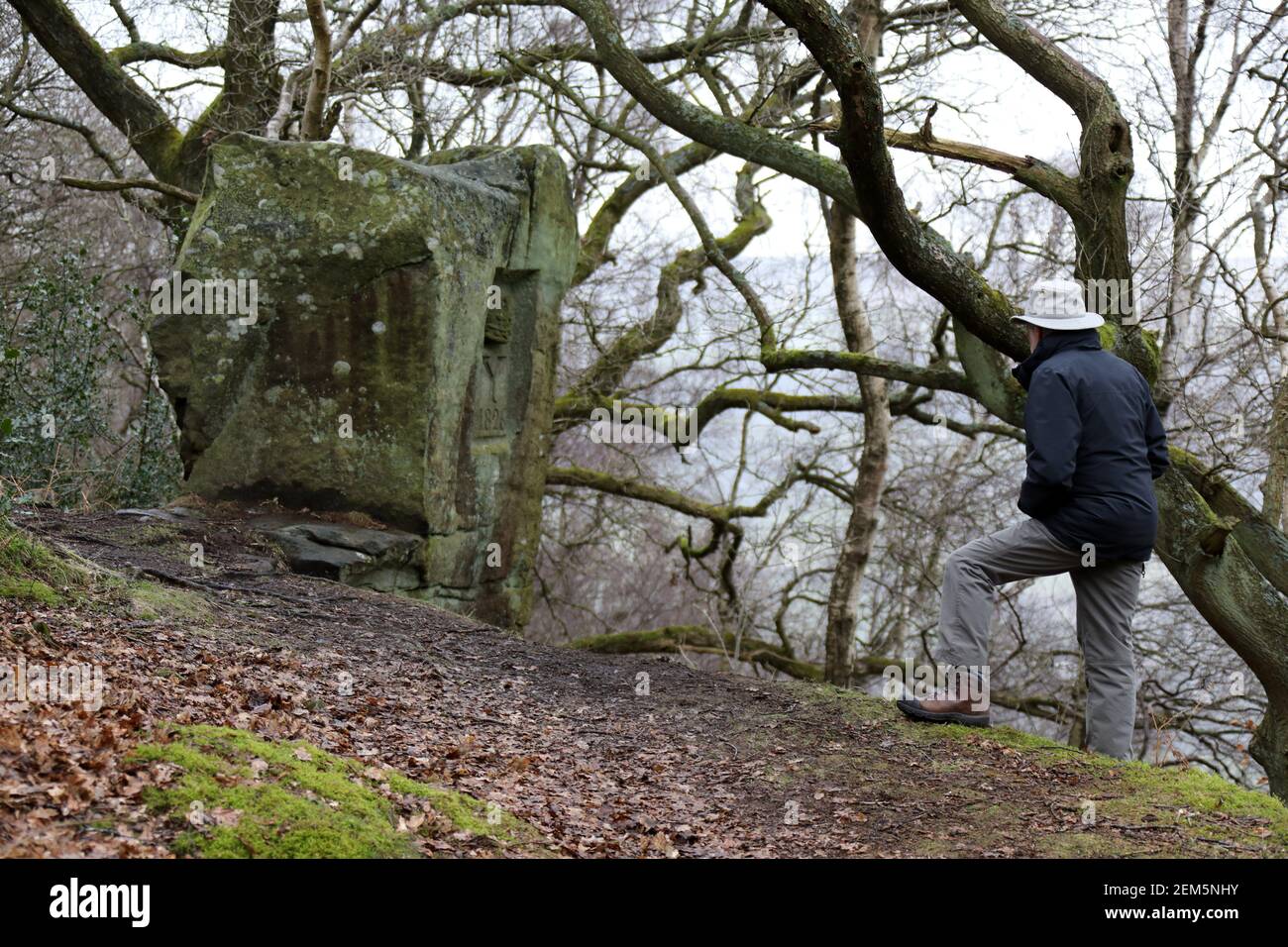 Historiker mit Blick auf den geschnitzten Stein des Duke of York Stanton Moor im Derbyshire Peak District Stockfoto