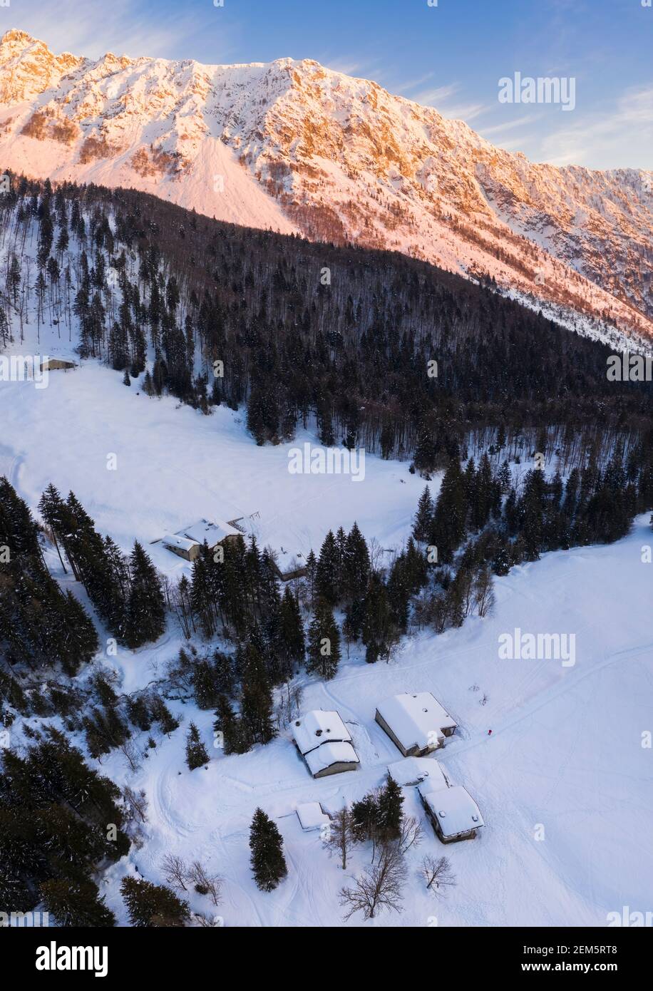 Luftaufnahme eines Winteruntergangs von Baite del Moschel, Oltressenda Alta, Valzurio, Val Seriana, Bergamo Bezirk, Italien. Stockfoto